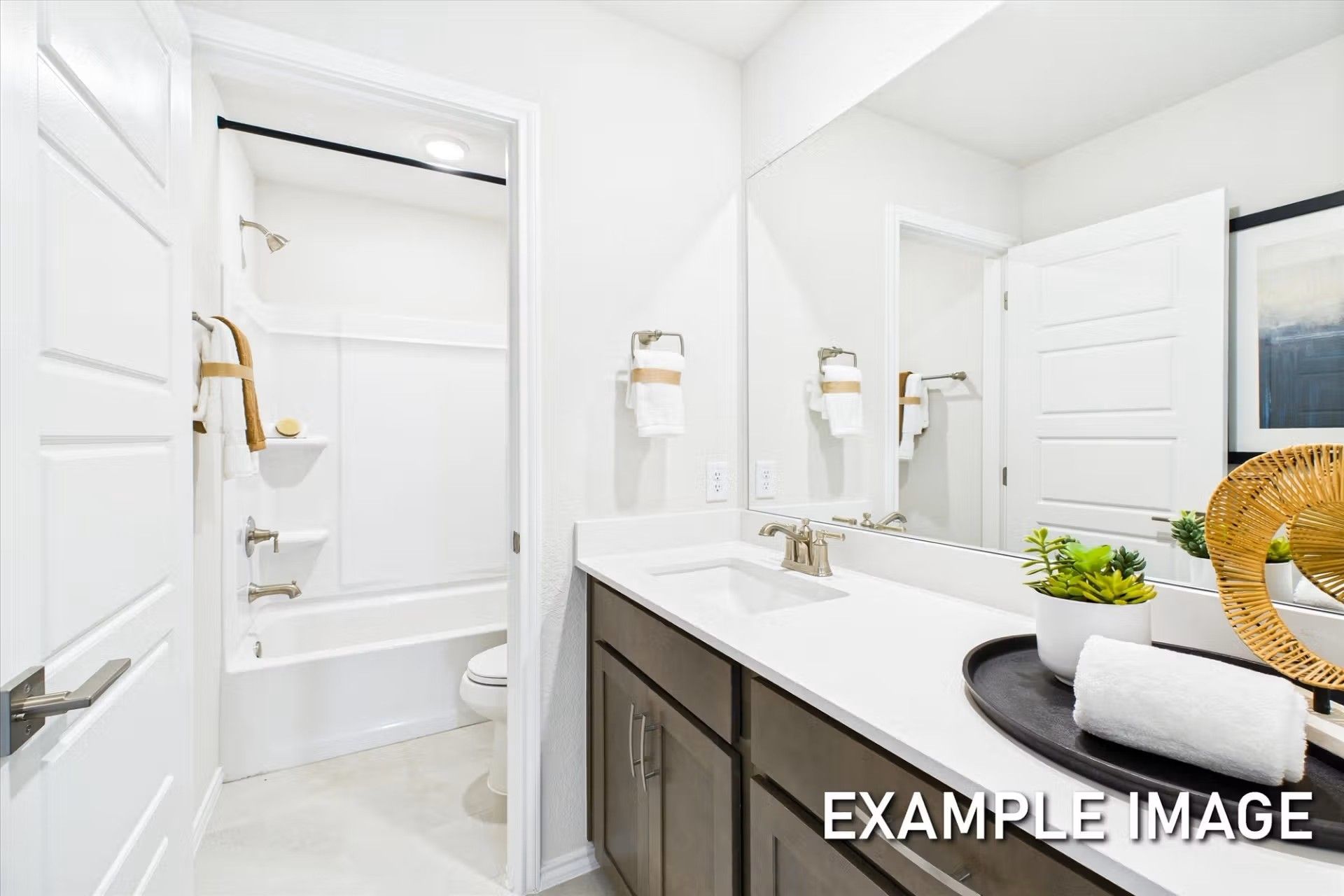 Modern bathroom with white vanity, large mirror, and tub-shower combo in The Brazos E floor plan at Heartland, Texas.