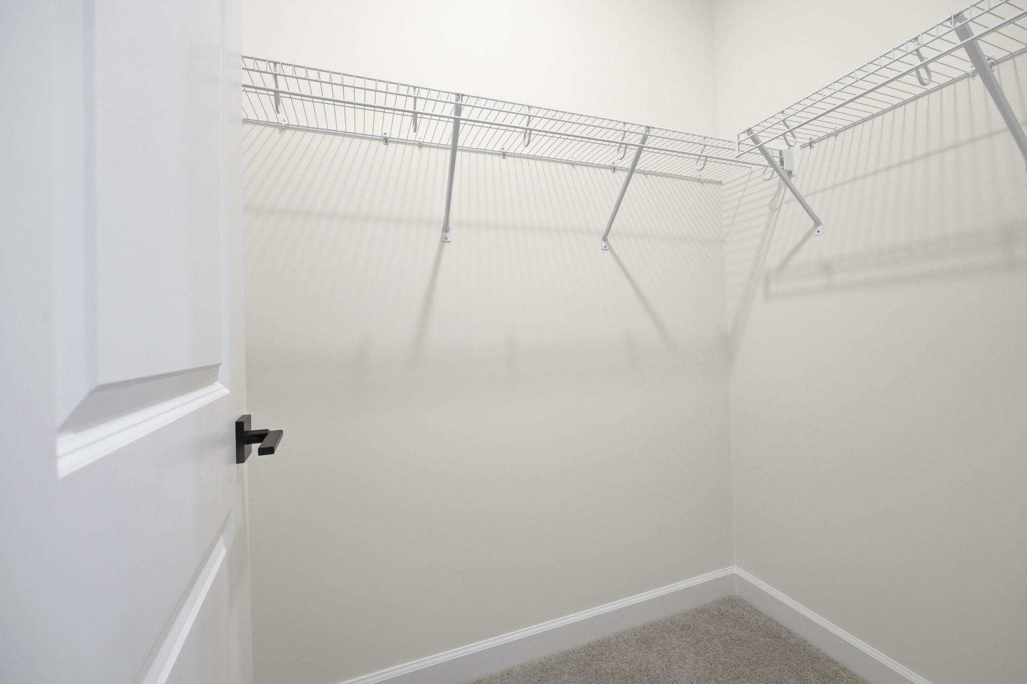 Spacious walk-in closet with wire shelving in the master suite of The Ashport K home design by Davidson Homes.
