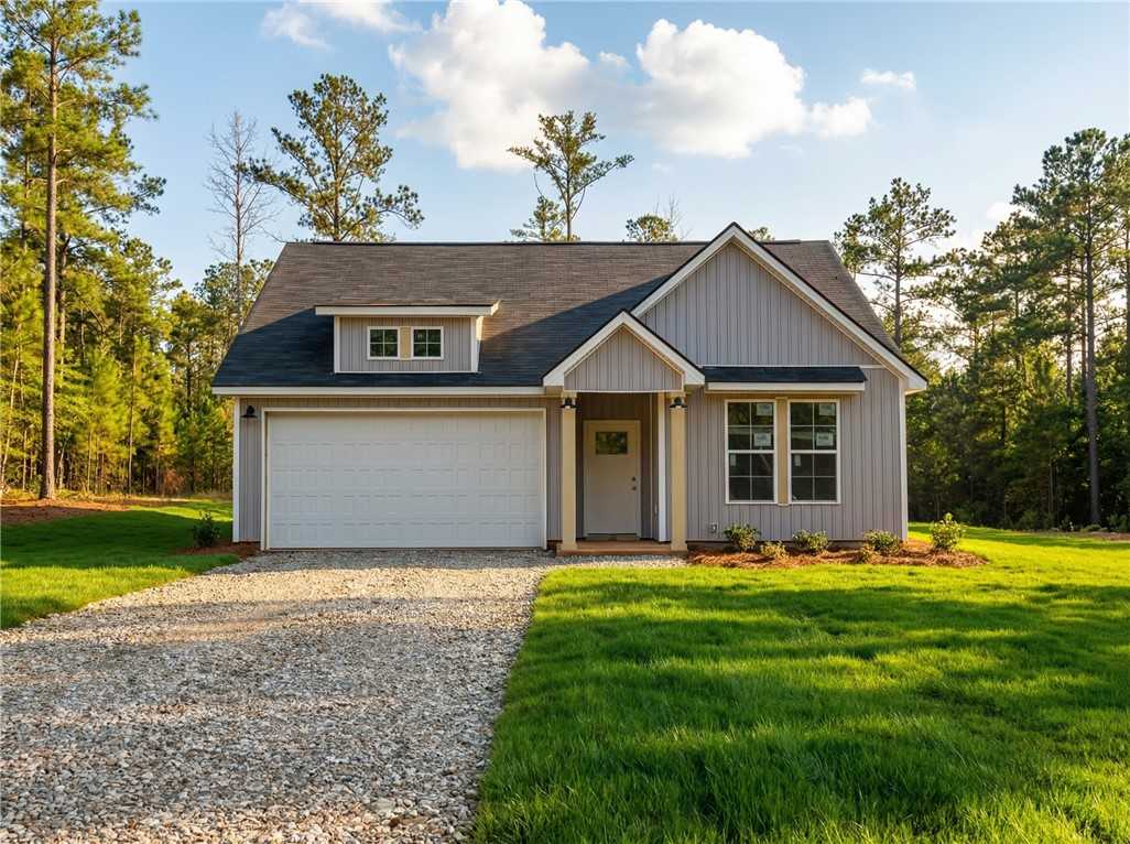 Modern gray-sided single-story home with 2-car garage, front porch, and pine surroundings in Silver Oak, Cusseta, Alabama