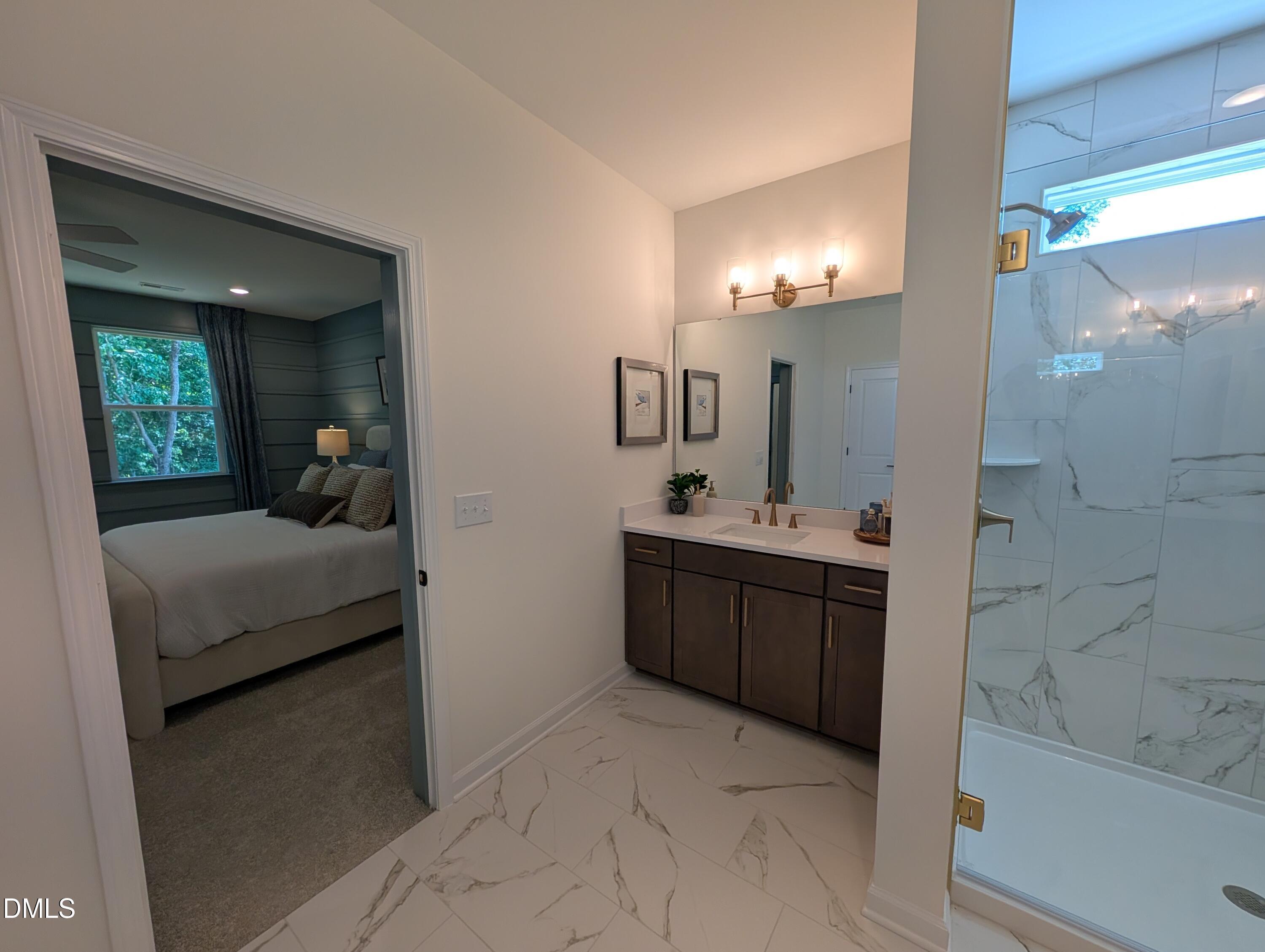 Modern bathroom vanity with marble tile floor and glass shower in The Aspen B floor plan at Wendell Ridge, North Carolina.