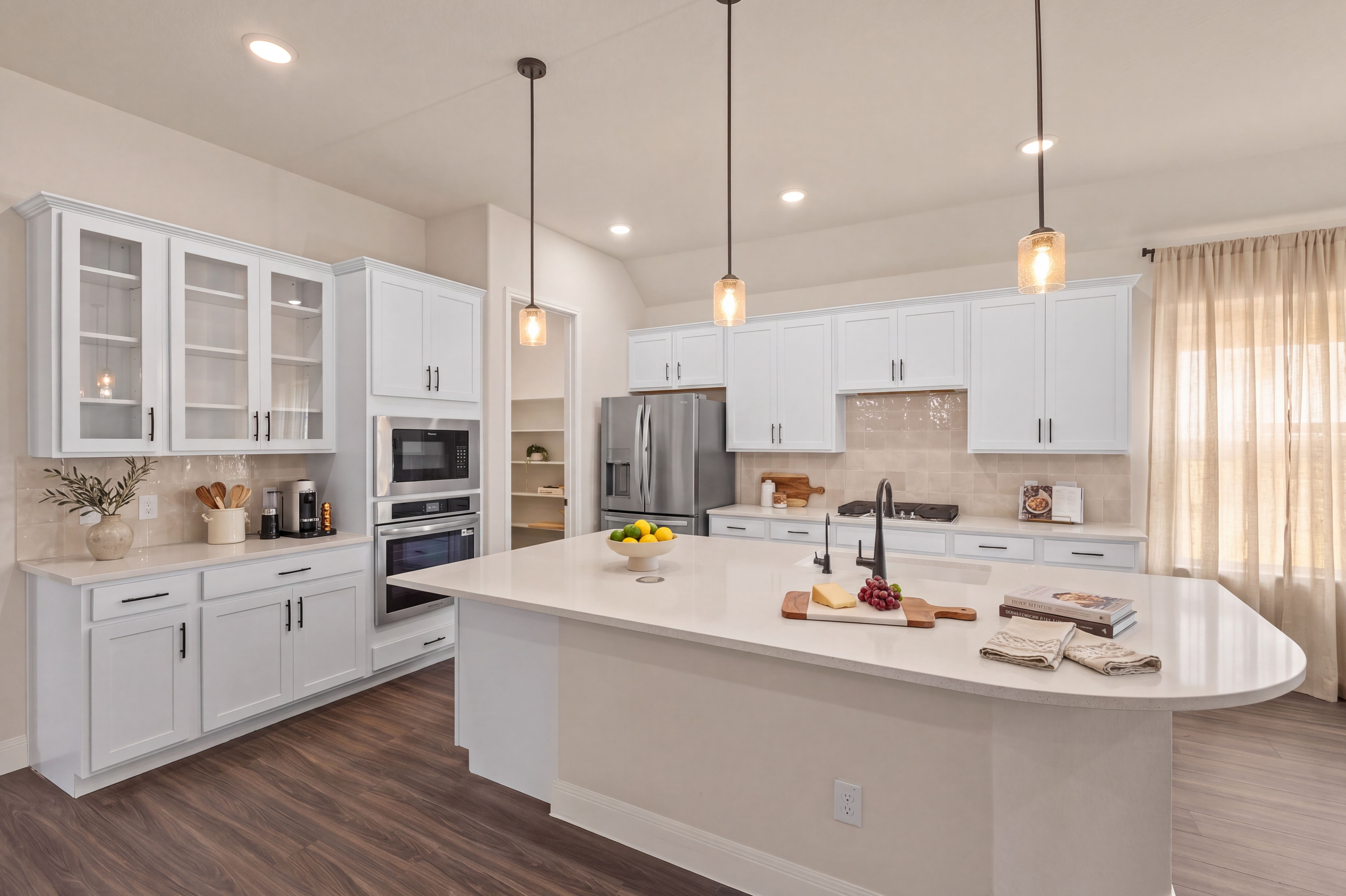 White cabinets and dark hardware in an open kitchen at Potranco Oaks in Castroville, TX