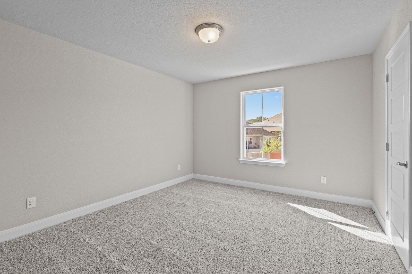 Spacious, carpeted secondary bedroom with neutral walls and natural light in The Jennings G home design.