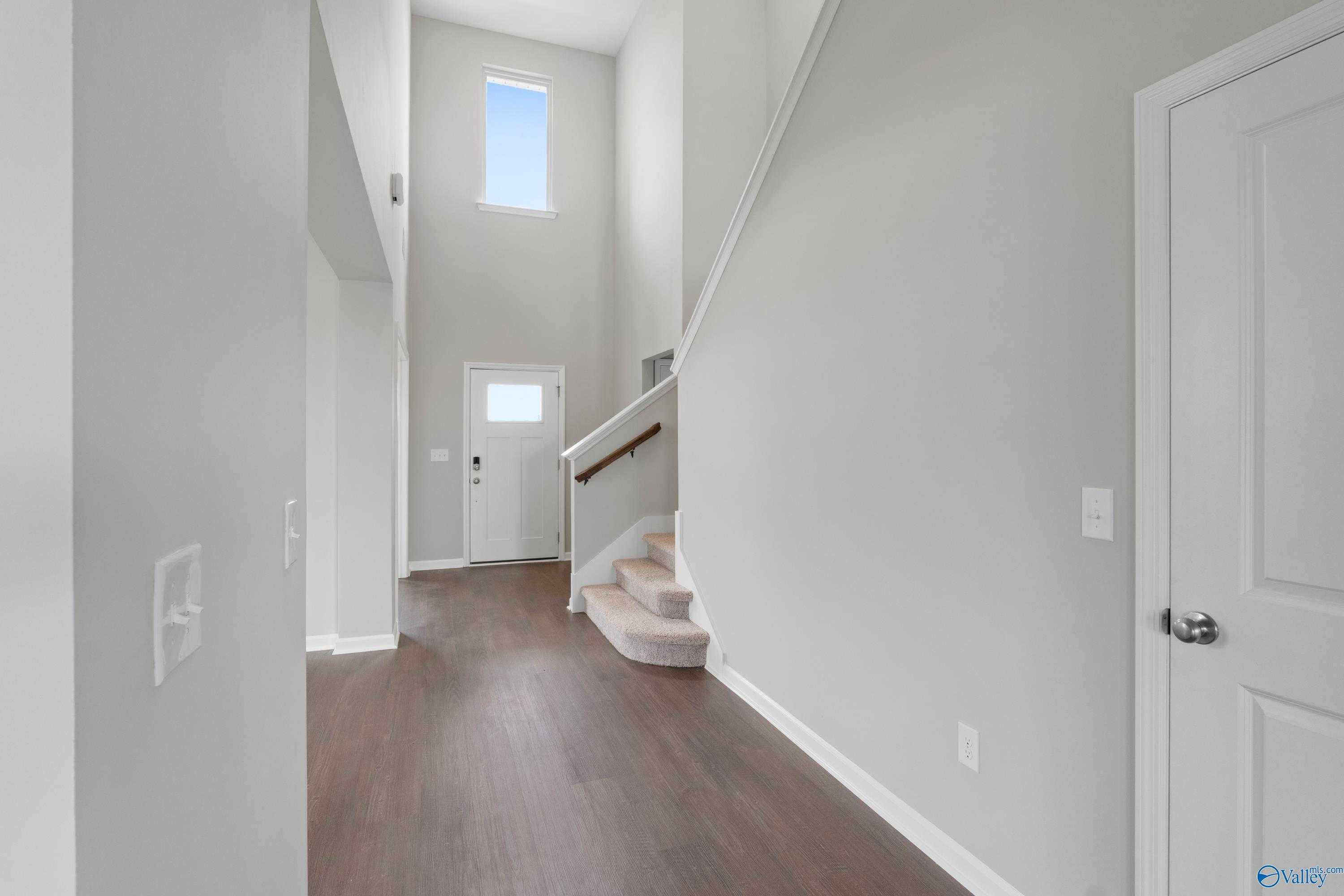 Grand two-story foyer with open staircase, hardwood floors, and neutral walls in Davidson Homes The Dorado, Athens, AL