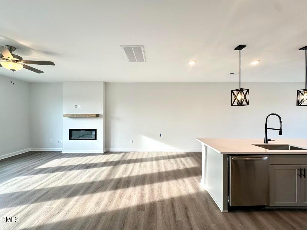 Bright open-concept living room with gas fireplace and kitchen island sink in Davidson Homes The Mitchell, Knightdale NC