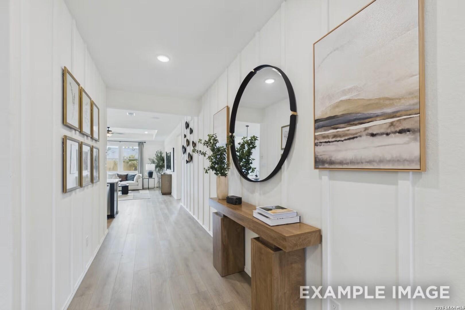 Bright, modern entryway with board and batten walls, wood console table, and wall art in The Laurel I, Rayburn Valley home.