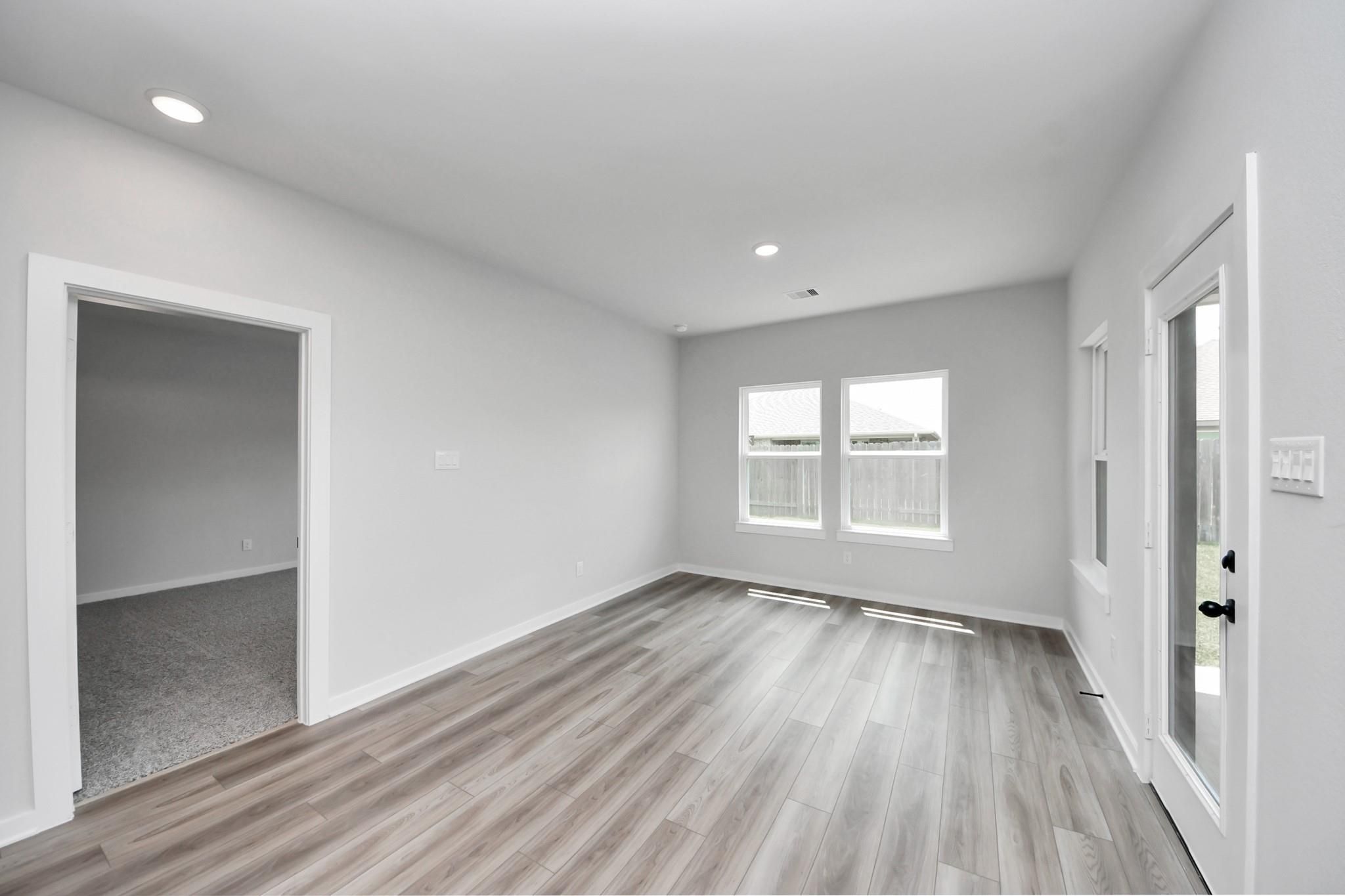 Bright living area with wood-look flooring and backyard access in The Everett C floor plan, River Ranch Meadows, Dayton.
