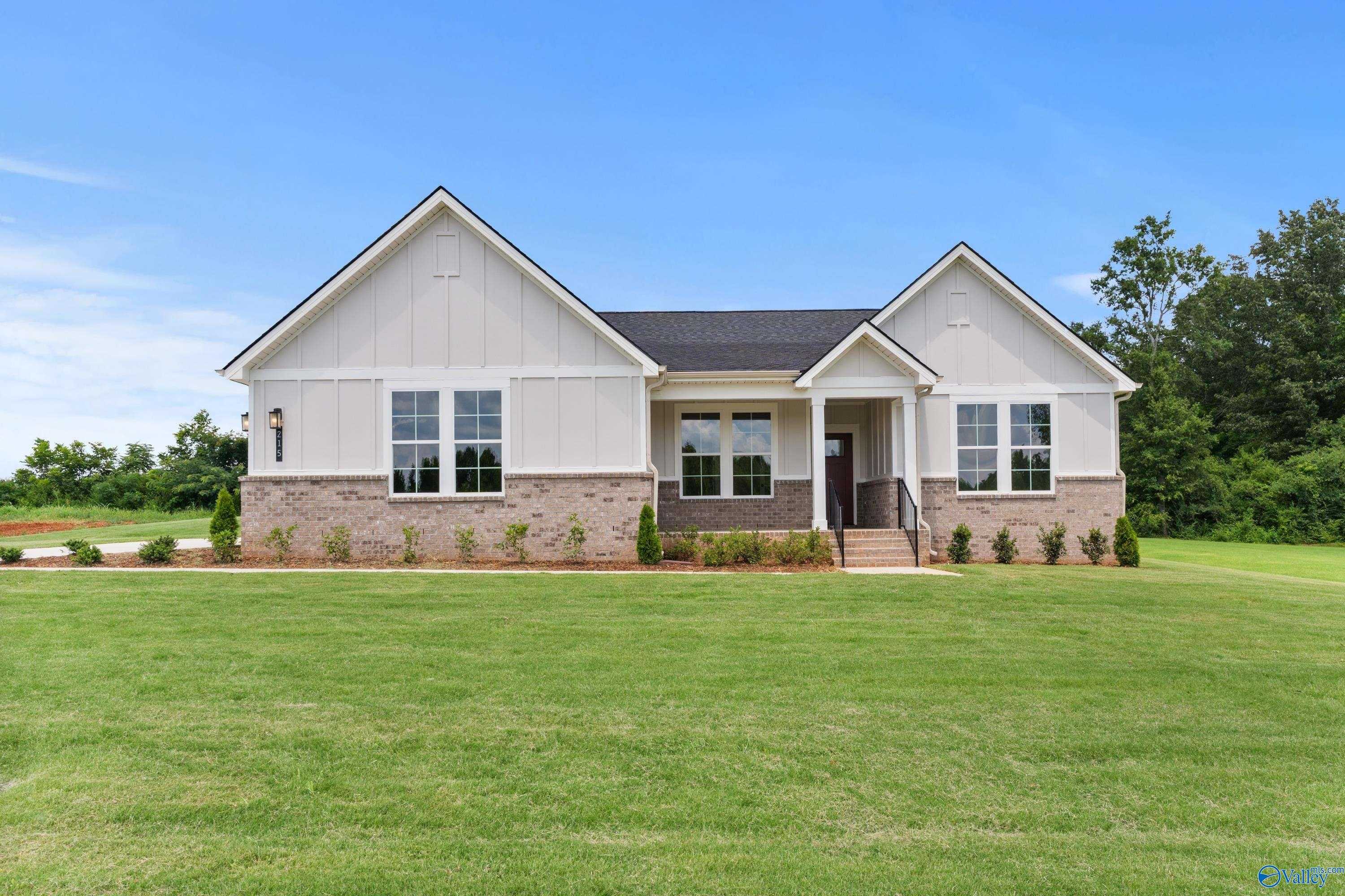 Modern white single-story Arcadia home with gabled roof, brick accents, and lush lawn in Riverton Preserve, Huntsville, Alabama