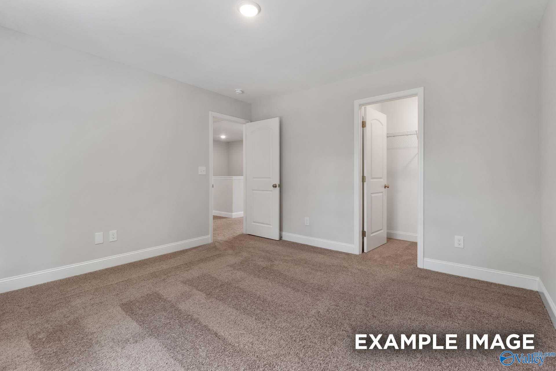 Spacious secondary bedroom with gray walls, plush carpet, adjacent bath and closet in Davidson Homes Shelby C, Meridianville AL