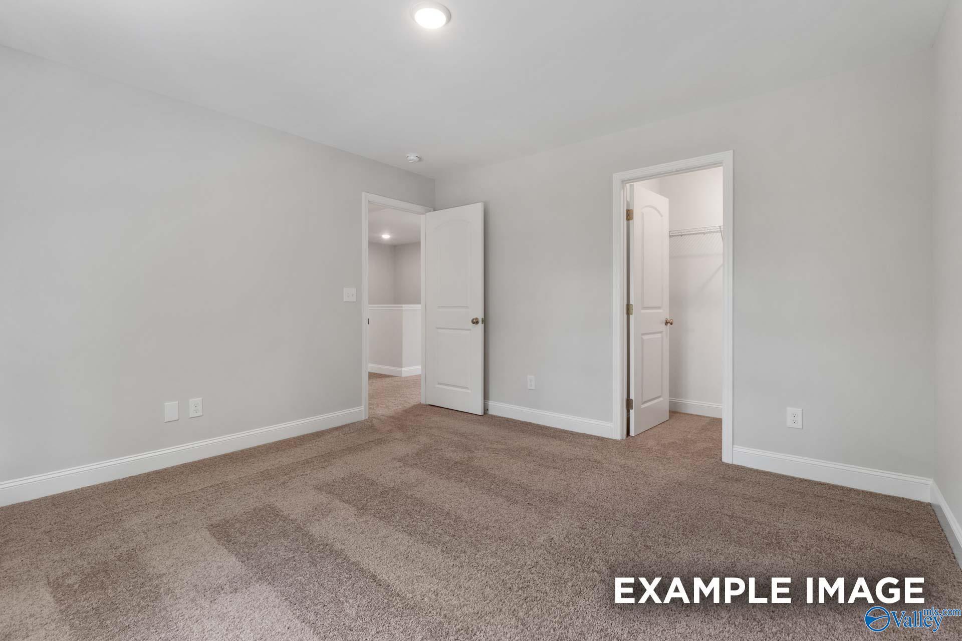Spacious secondary bedroom with gray walls, plush carpet, adjacent bath and closet in Davidson Homes Shelby C, Meridianville AL
