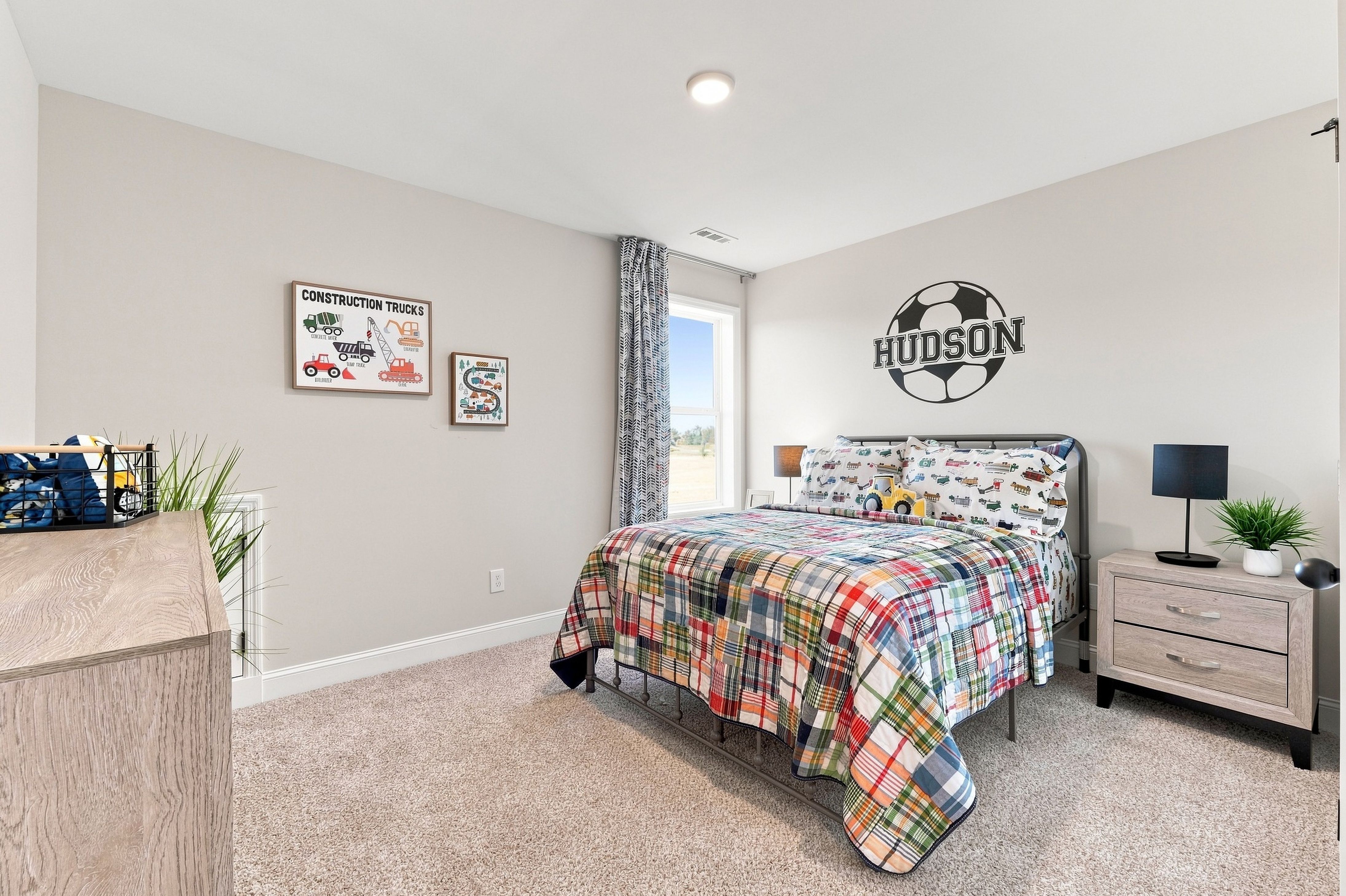 Bright kids bedroom at Bailey Park in Fayetteville, TN by Davidson Homes with plaid bedding and soccer wall decal