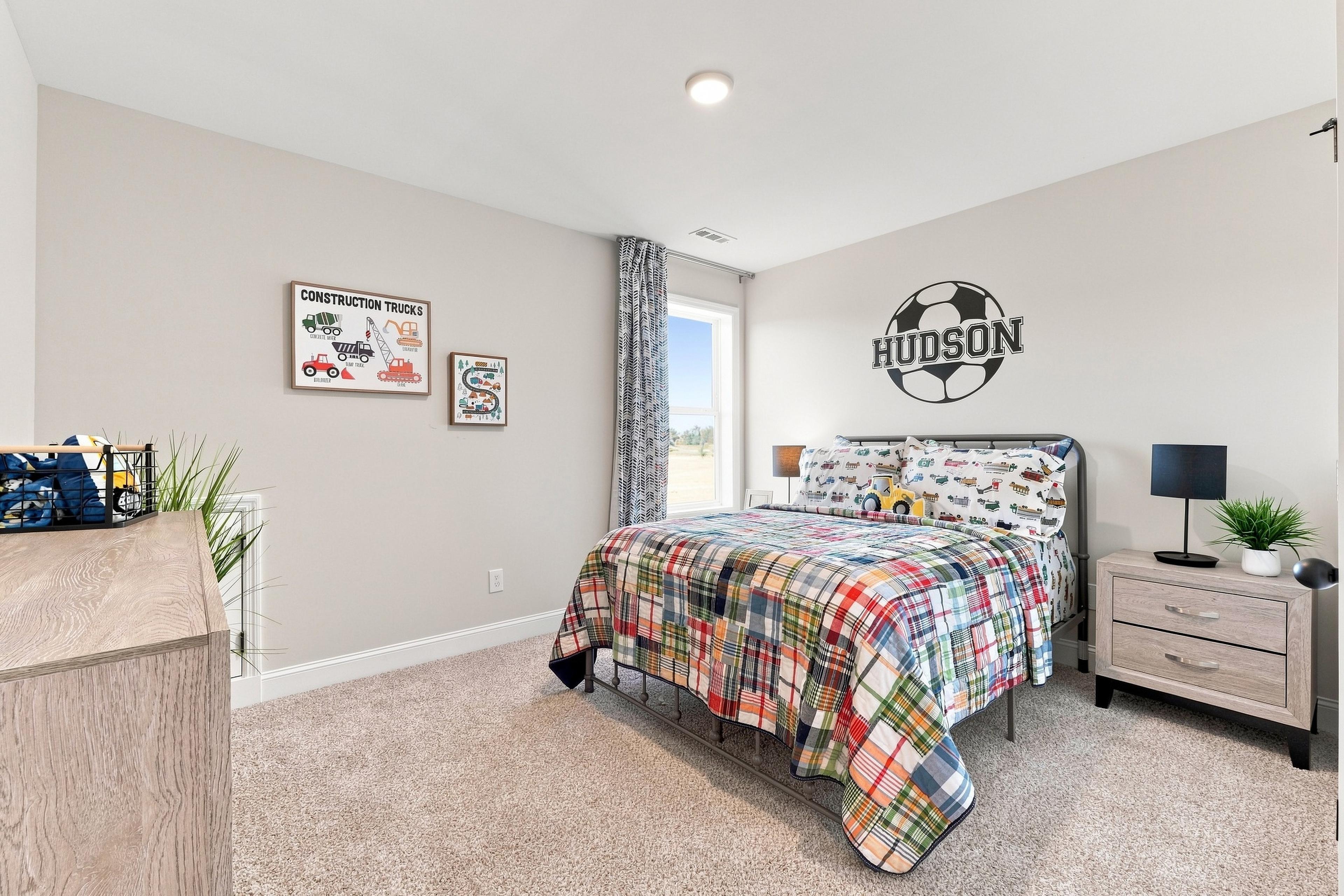 Bright kids bedroom at Bailey Park in Fayetteville, TN by Davidson Homes with plaid bedding and soccer wall decal