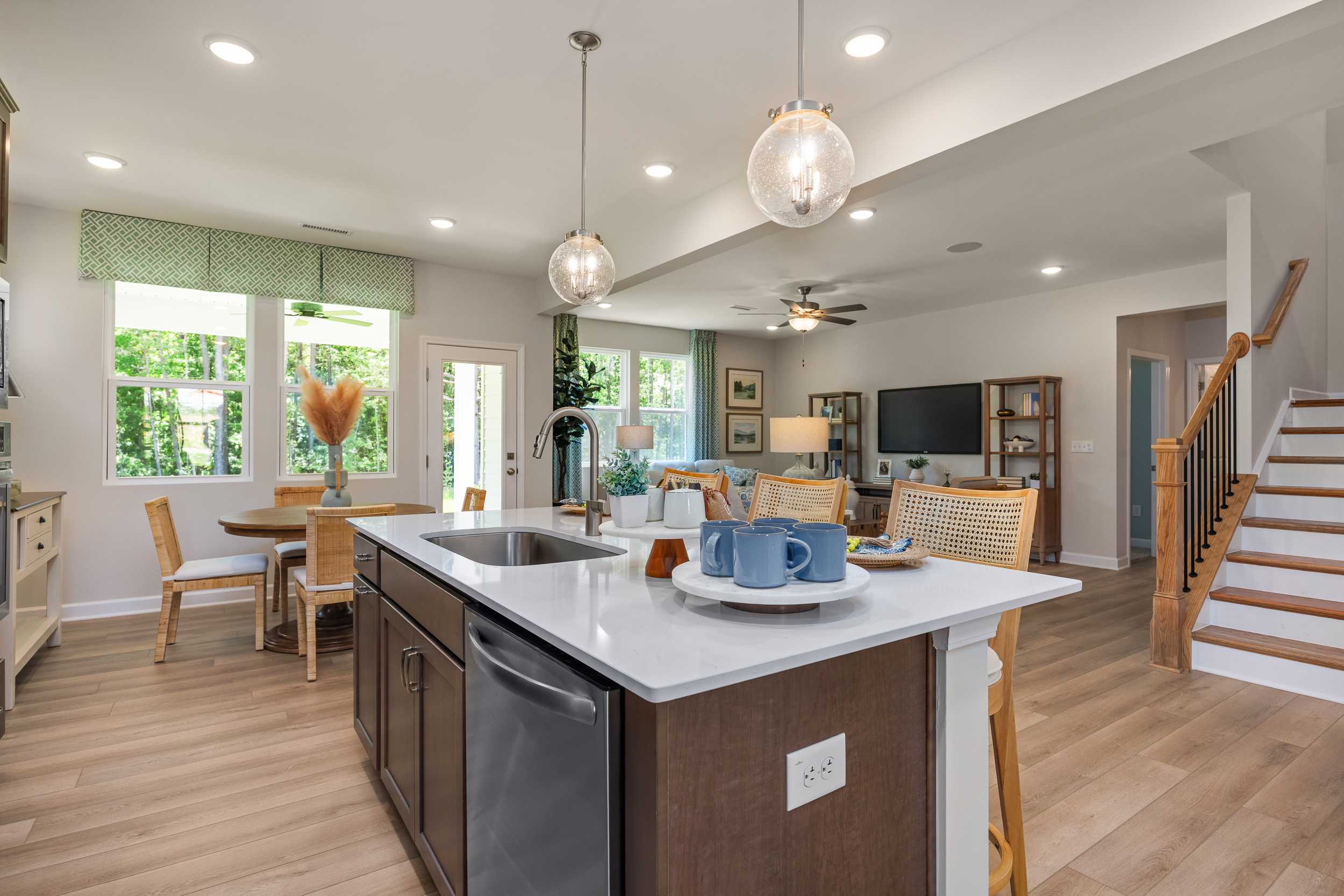 Open-concept kitchen and living area at Retreat at North Main in Lillington NC with quartz island, hardwood floors, and pendant lights
