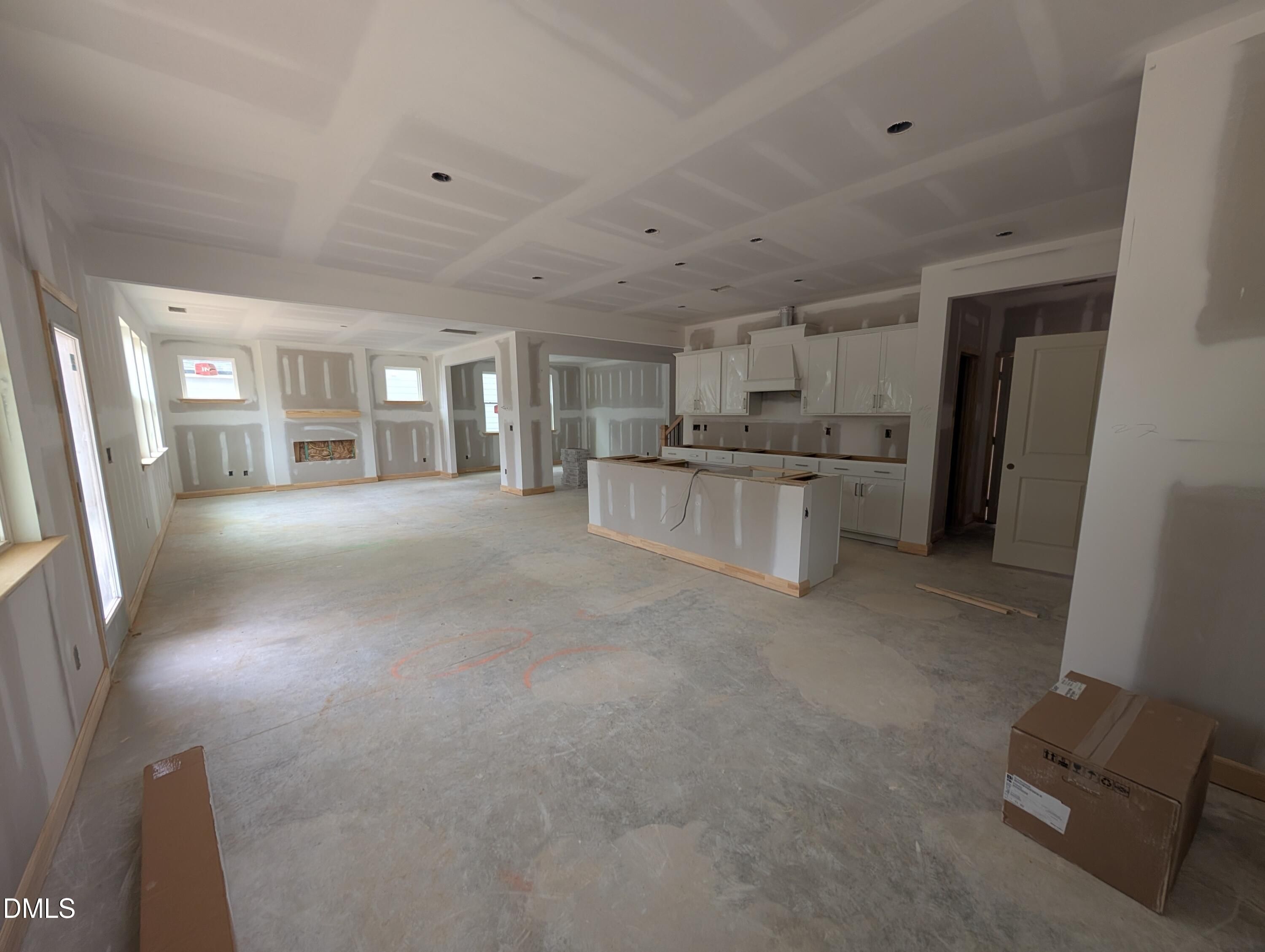 Open-concept kitchen with island and white cabinetry under construction in Davidson Homes The Beech plan, Wendell Ridge, NC