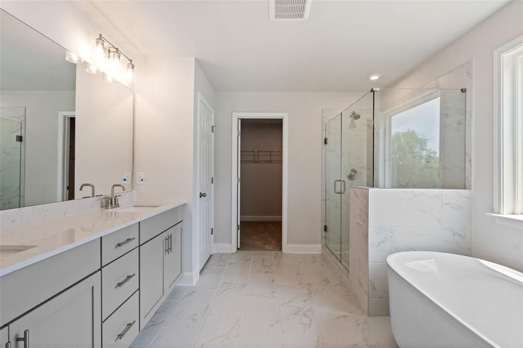 Luxurious master bathroom with double vanity, freestanding tub, and glass shower in Davidson Homes The Hickory B at Wehunt Meadows, Hoschton, GA