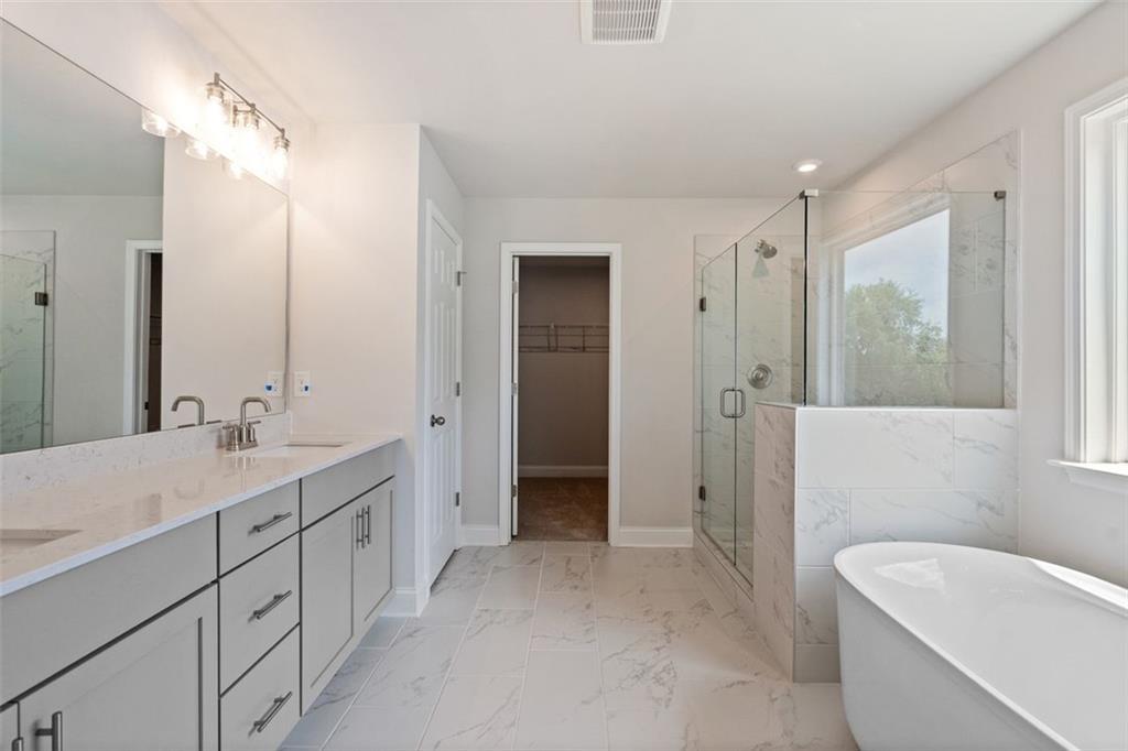 Luxurious master bathroom with double vanity, freestanding tub, and glass shower in Davidson Homes The Hickory B at Wehunt Meadows, Hoschton, GA