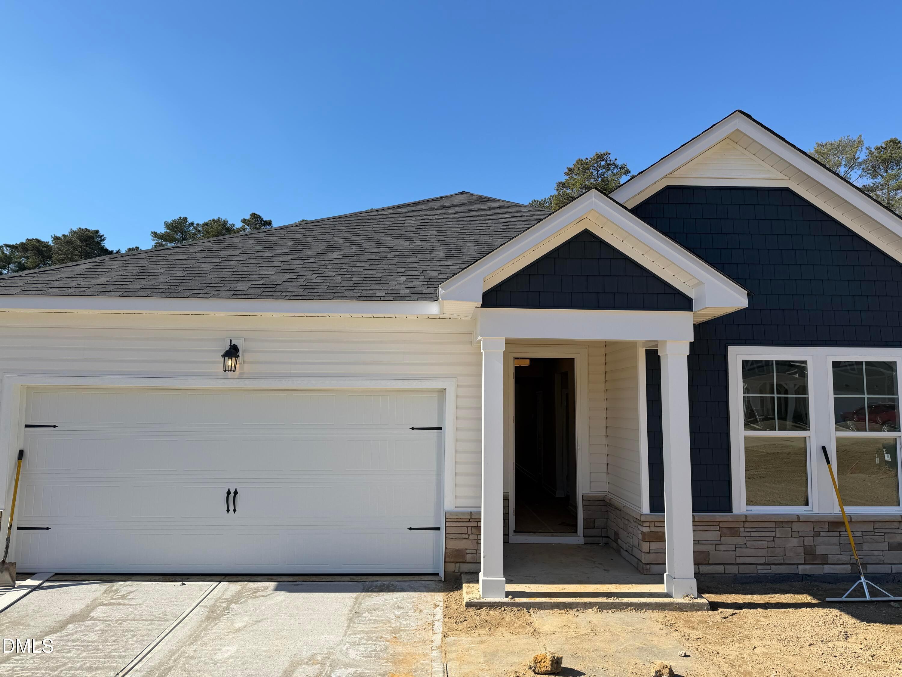 Modern navy blue and white 1-story home with 2-car garage, covered front porch, and gabled roof in Wellers Knoll, Lillington, NC
