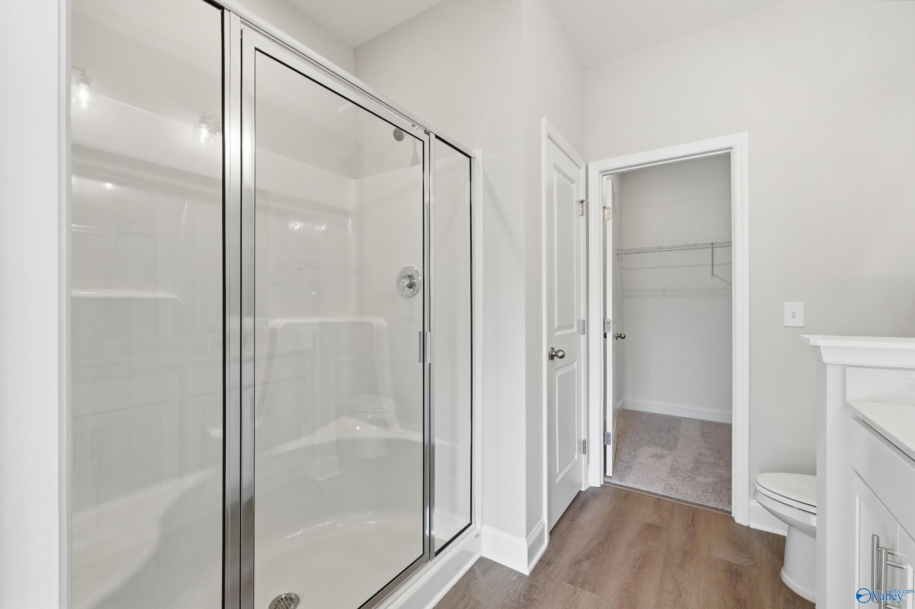 Modern master bathroom with frameless glass shower, white subway tiles, vanity sink, and linen closet in The Asheville C, Huntsville AL