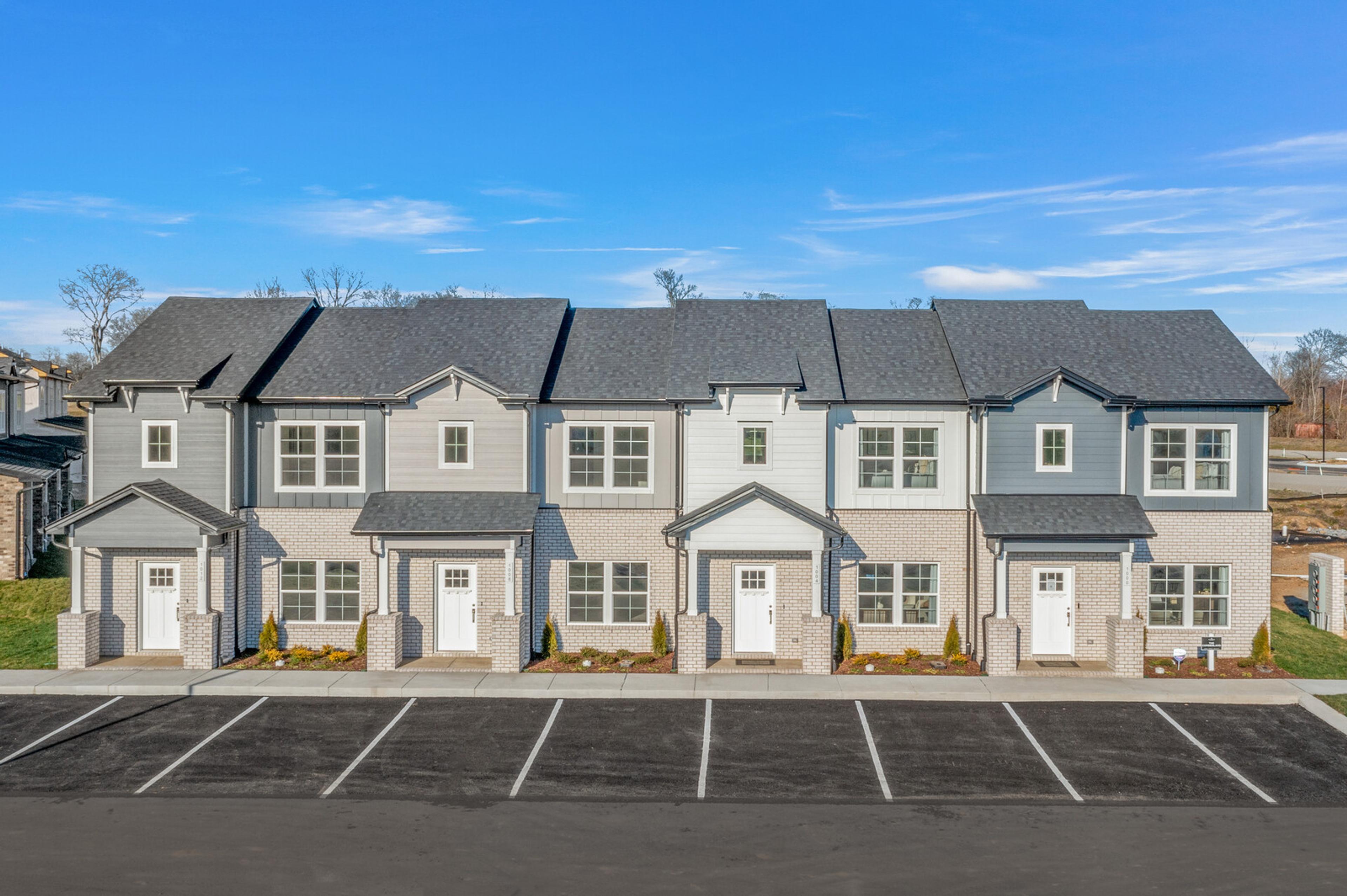 Row of modern gray townhomes with white doors and landscaping at The Towns at Red River in Gallatin, Tennessee