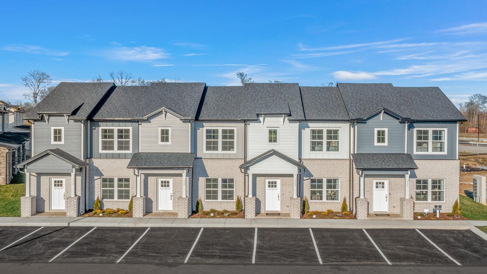 Row of modern gray townhomes with white doors and landscaping at The Towns at Red River in Gallatin, Tennessee
