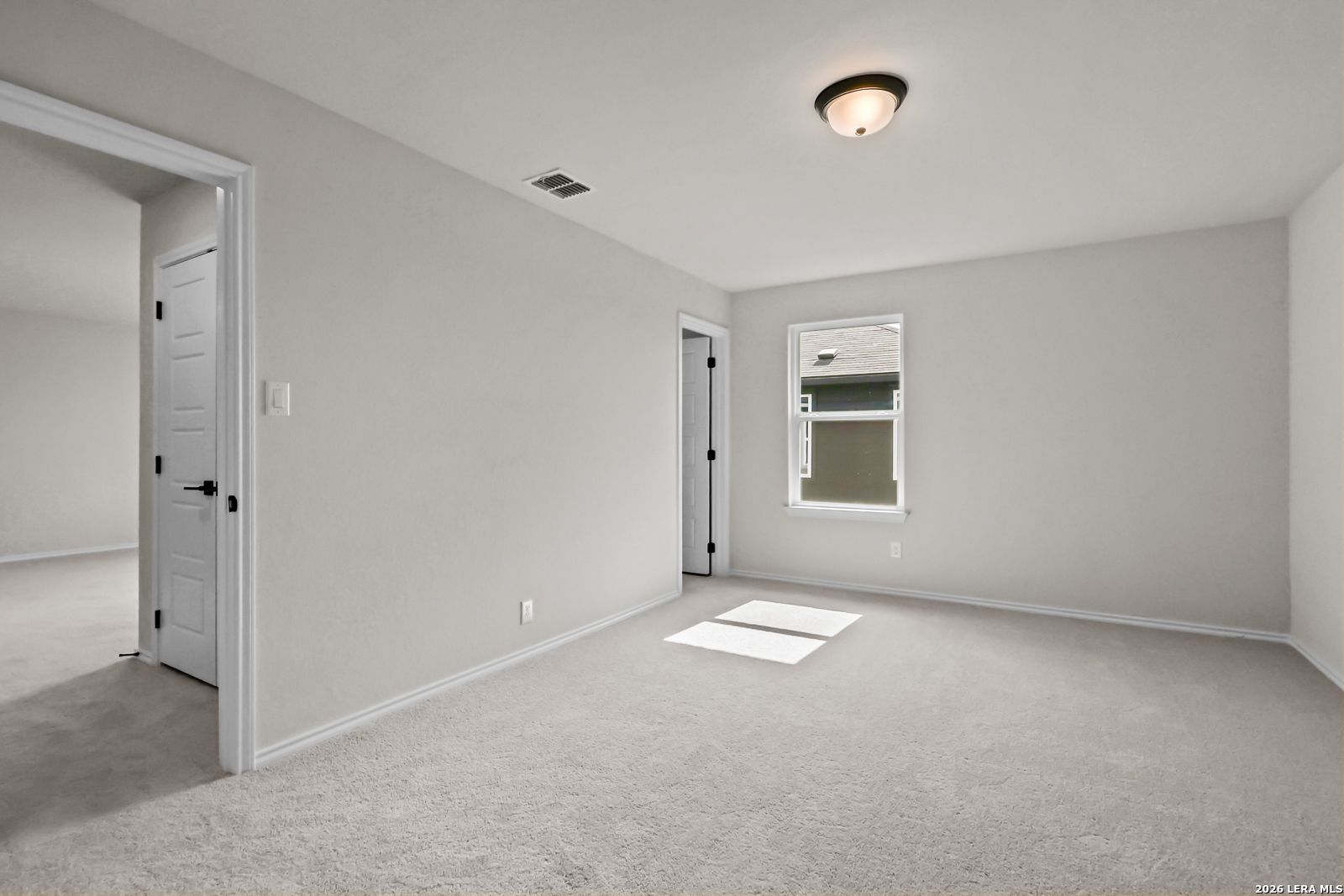 Bright, carpeted bedroom with neutral walls in The Douglas C floor plan by Davidson Homes in Hannah Heights, Seguin, Texas.