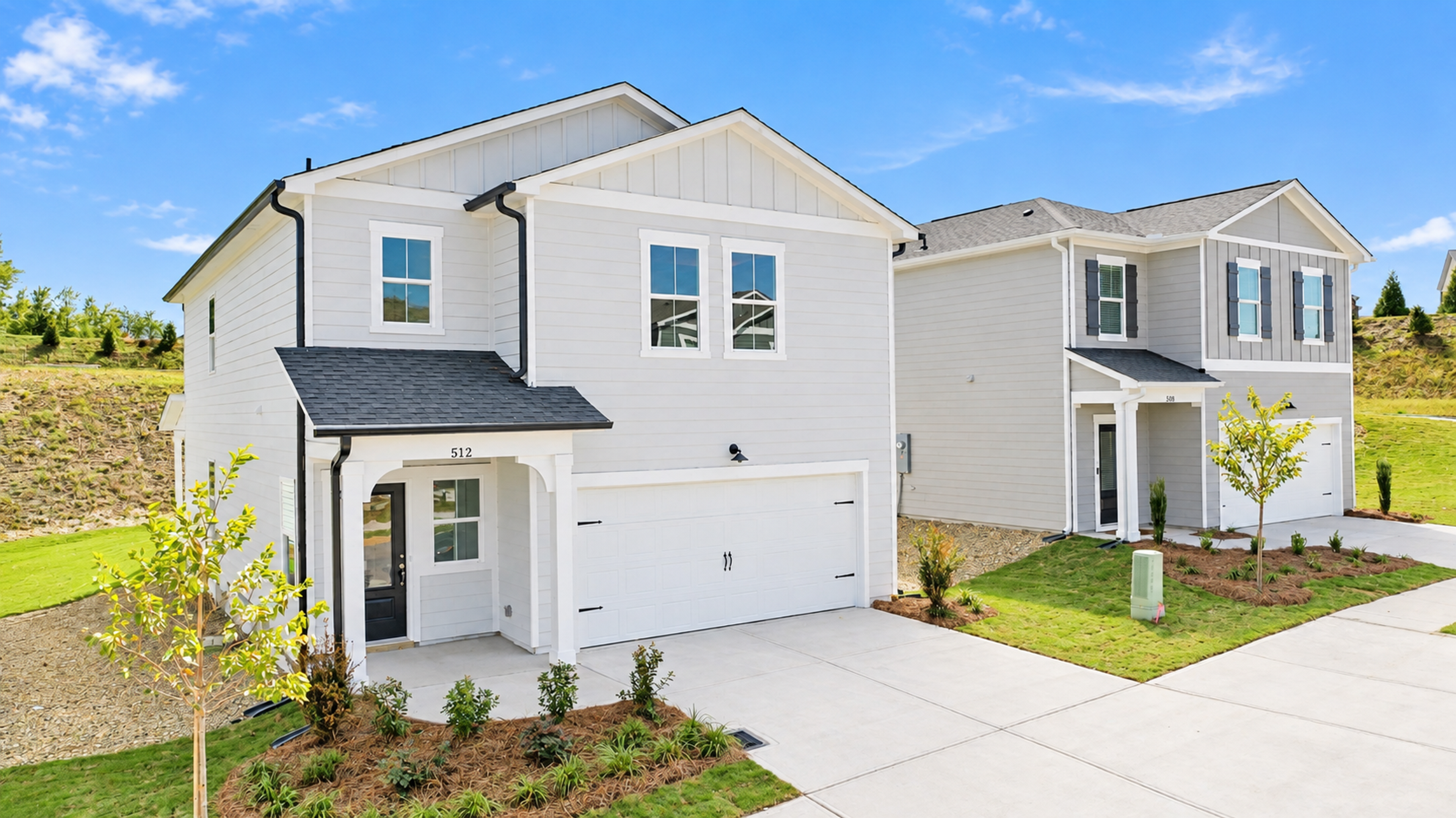 New construction homes by Davidson Homes at The Bluffs in Canton, Georgia featuring modern siding and two-car garages.
