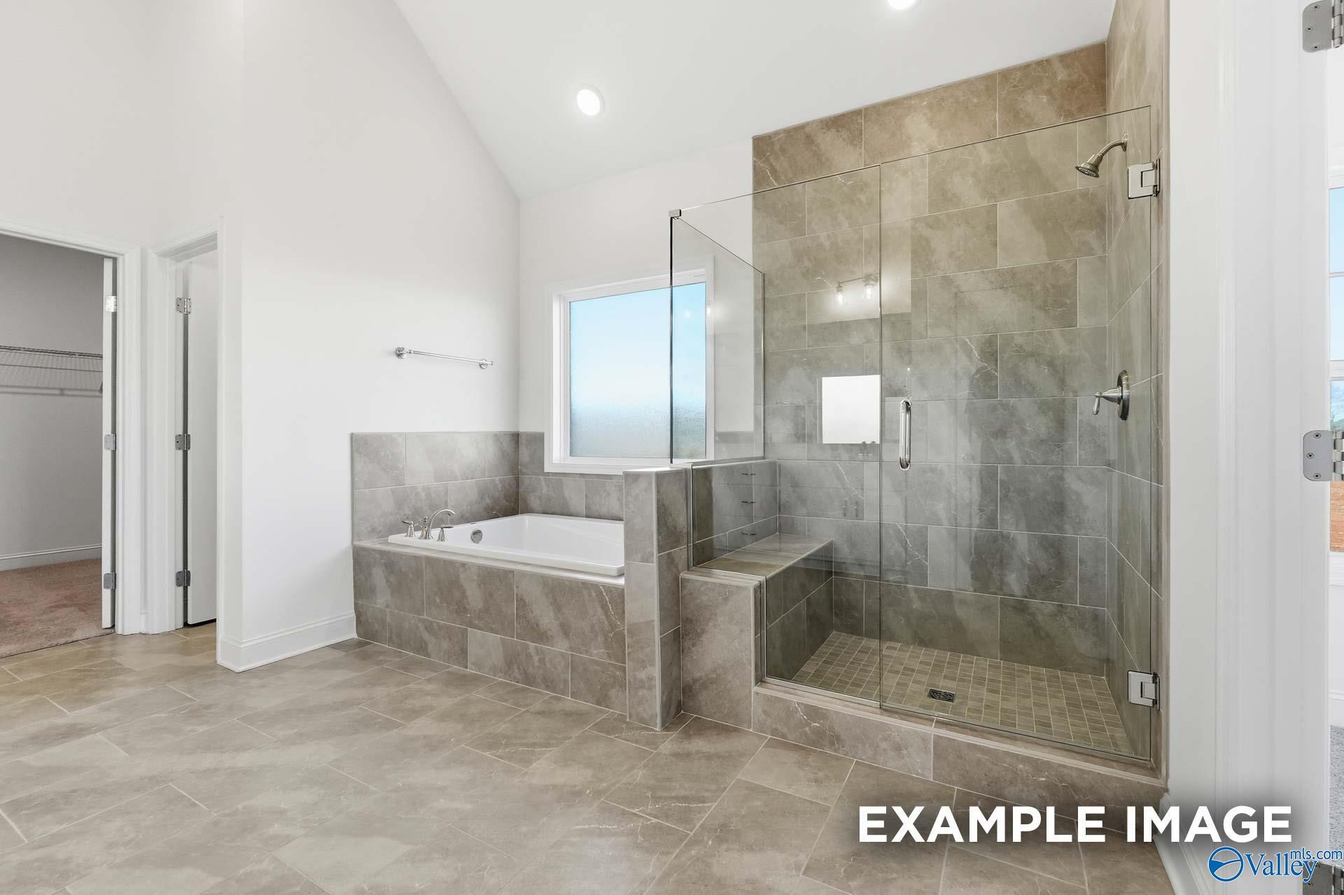 Luxurious primary bathroom with tiled walk-in shower and soaking tub in The Valencia floor plan, Briercreek, Meridianville.