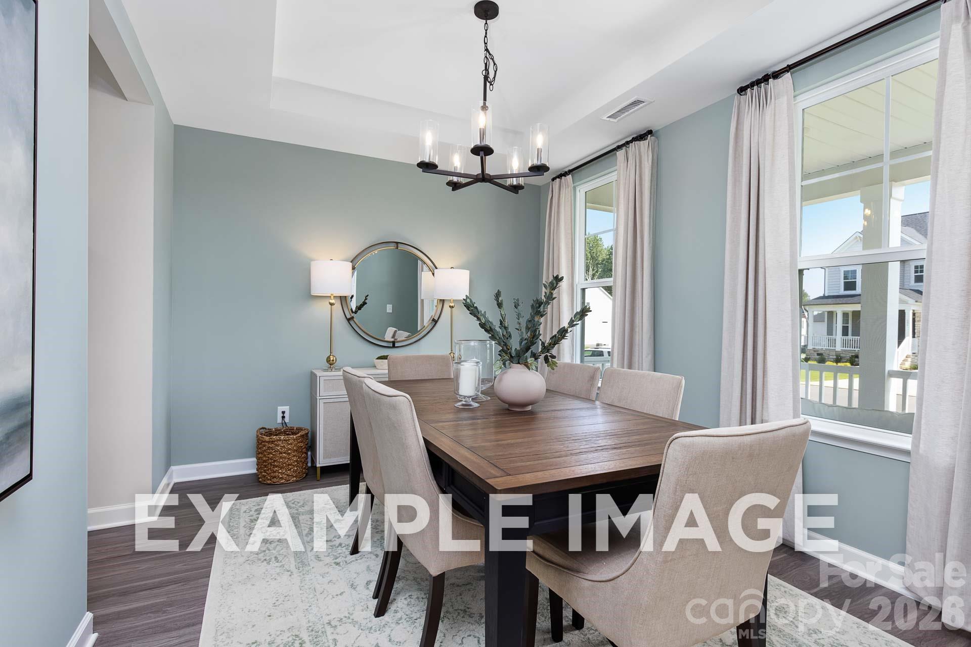 Elegant formal dining room with chandelier in The Willow B floor plan at Windgate, Mooresville, North Carolina.