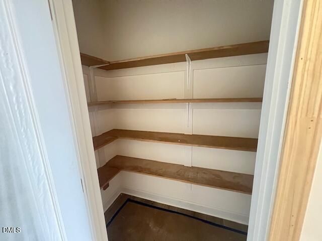 Walk-in pantry with wooden shelving in The Hickory II B floor plan at Retreat at North Main in Lillington, North Carolina.