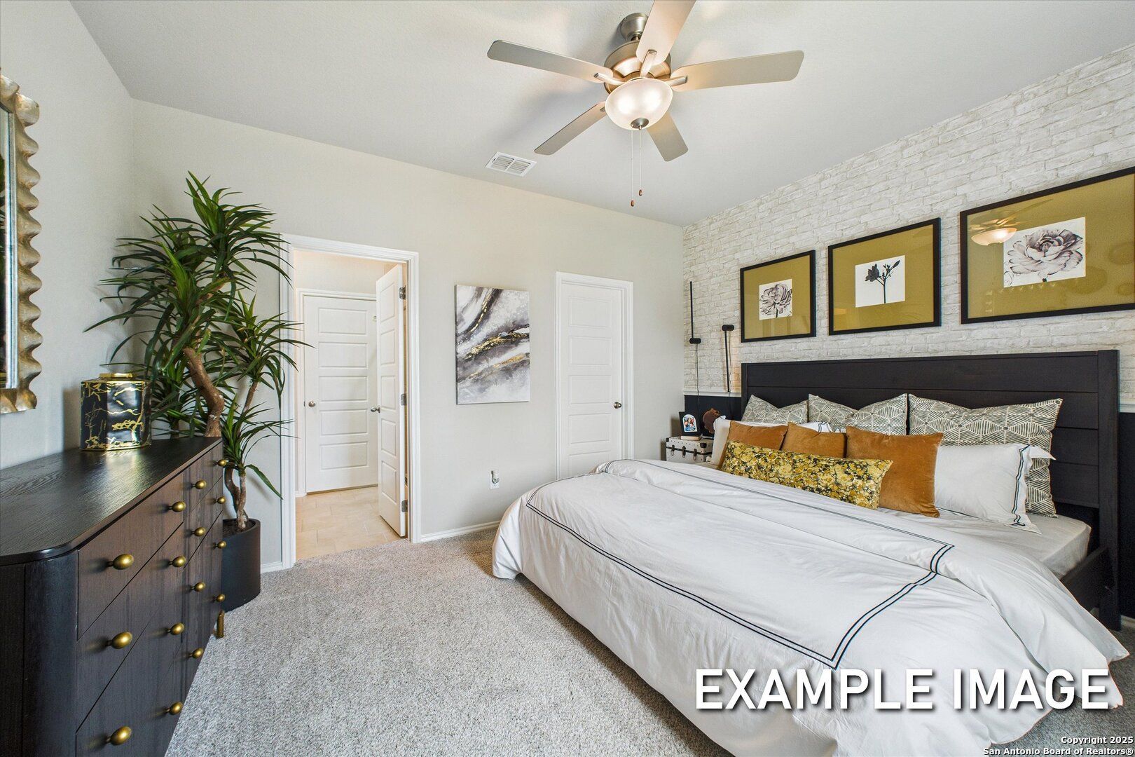 Elegant master bedroom with king bed, ceiling fan, black headboard, and modern artwork in Davidson Homes The Sabine C, Agave, San Antonio