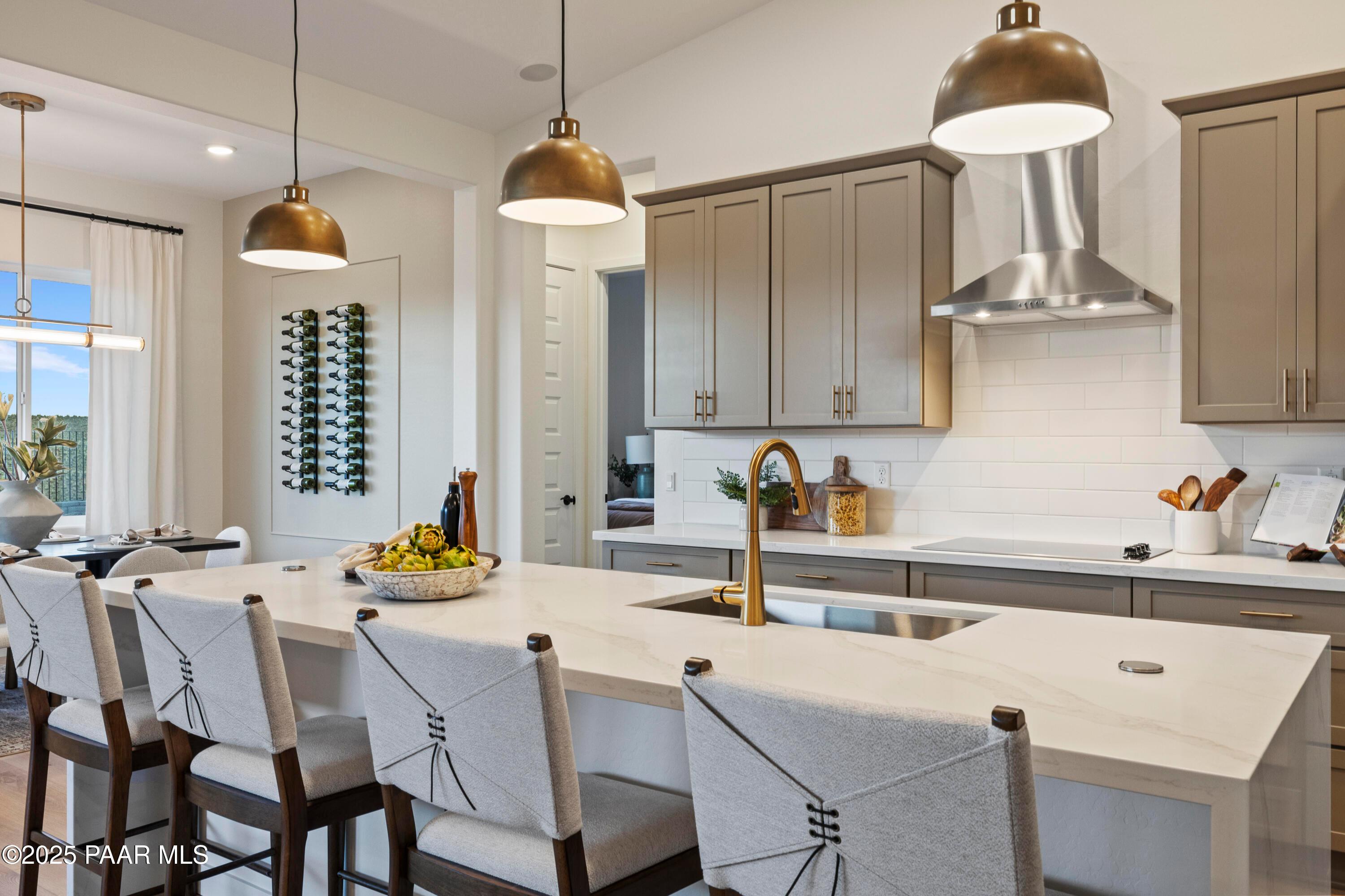 Modern kitchen island with white quartz countertop, gold faucet, subway tile backsplash in Davidson Homes The Blaze D, Prescott AZ