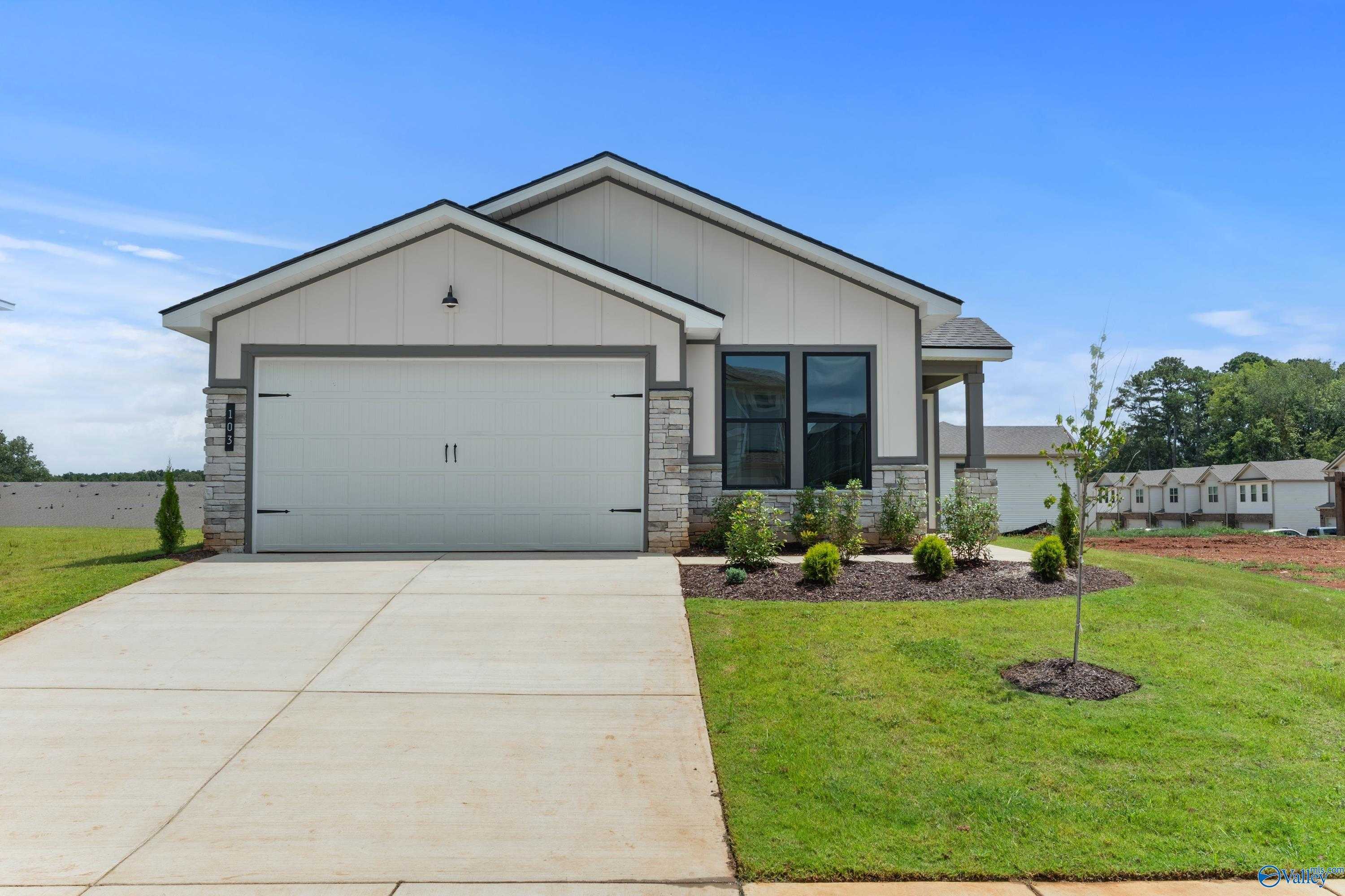Modern 1-story home with 2-car garage, white siding, and landscaped front yard in Evergreen Mill, Madison, Alabama