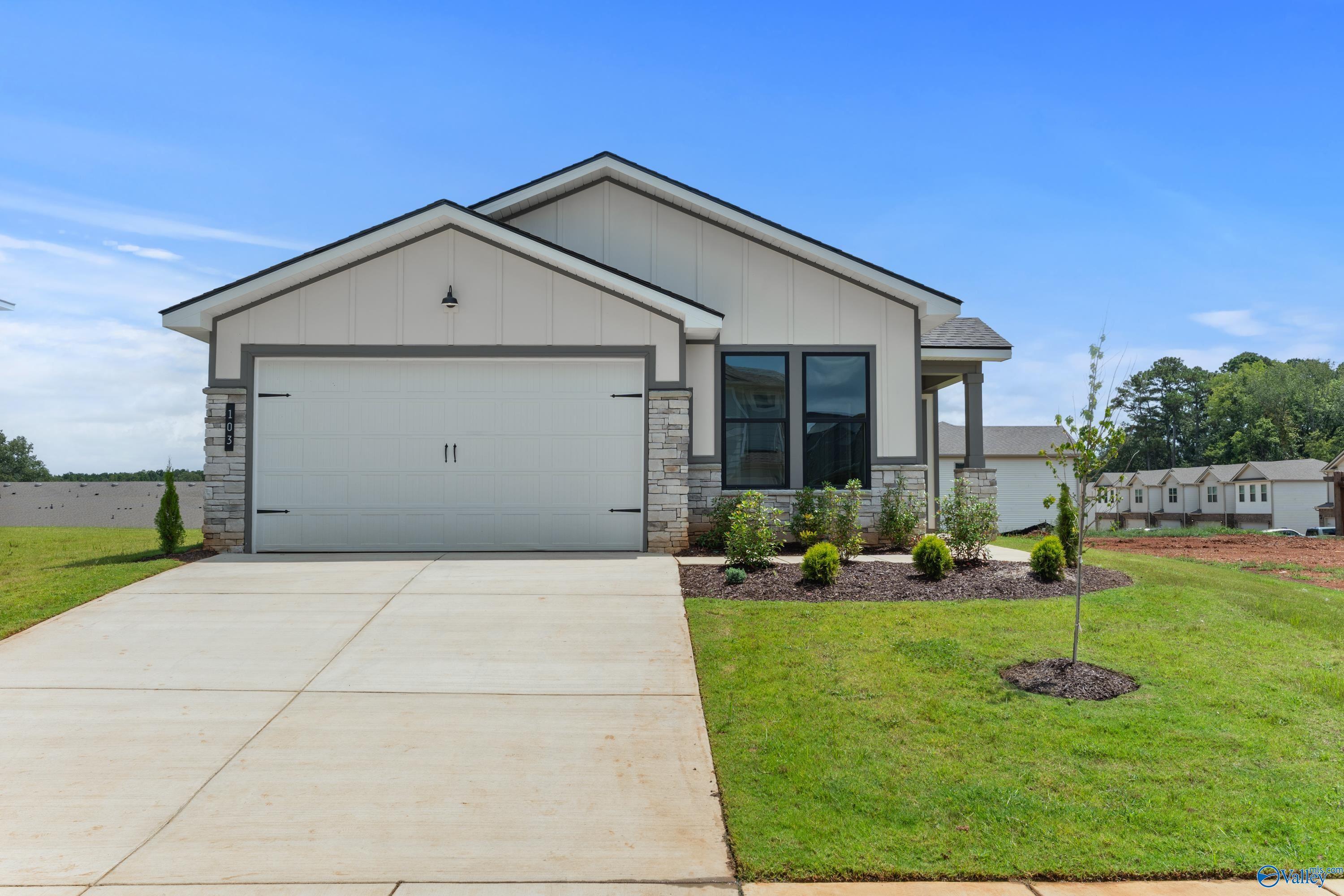 Modern 1-story home with 2-car garage, white siding, and landscaped front yard in Evergreen Mill, Madison, Alabama