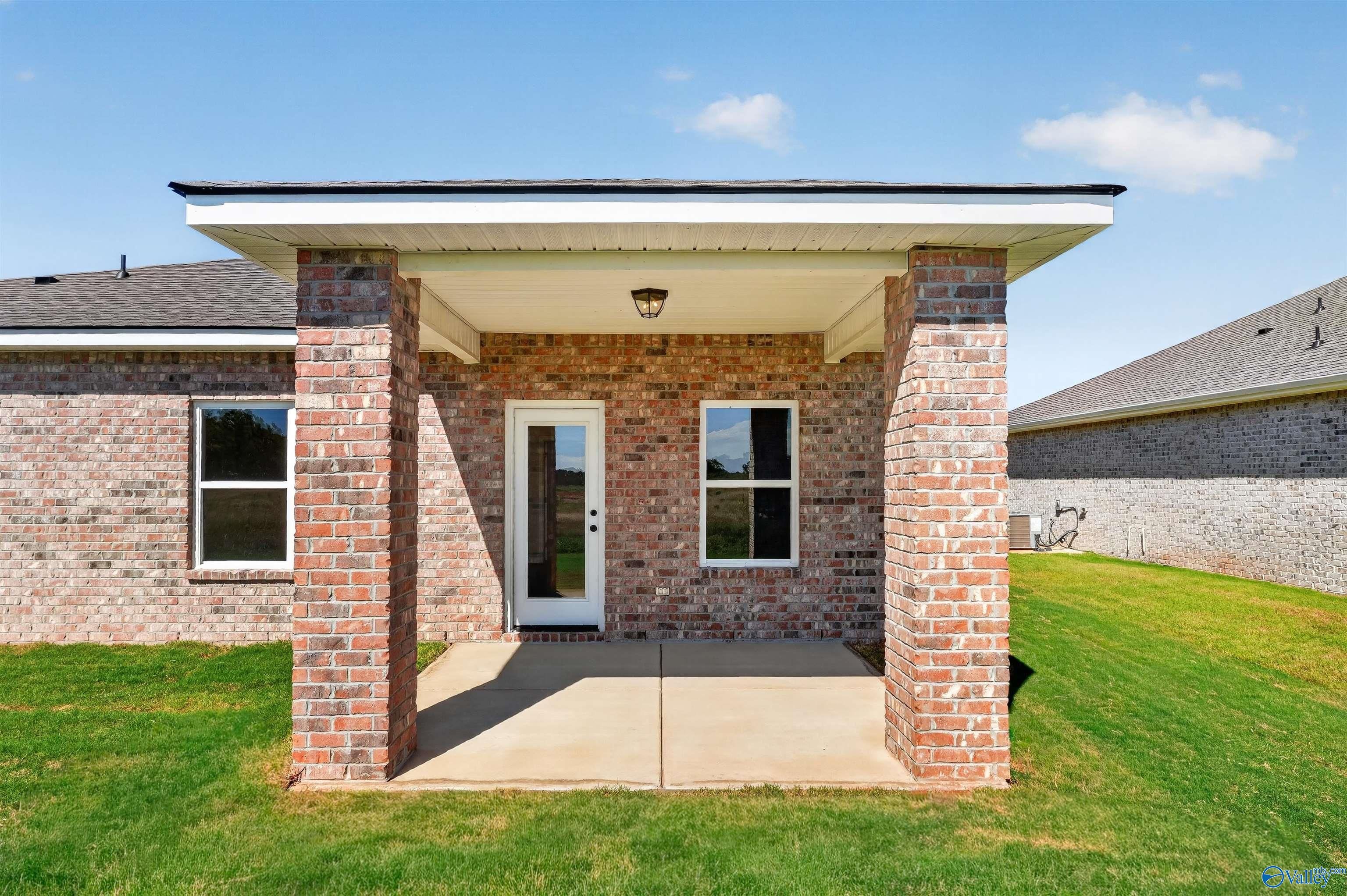 Covered brick patio with glass back door at Davidson Homes The Butler plan in Clearview, Hazel Green, Alabama