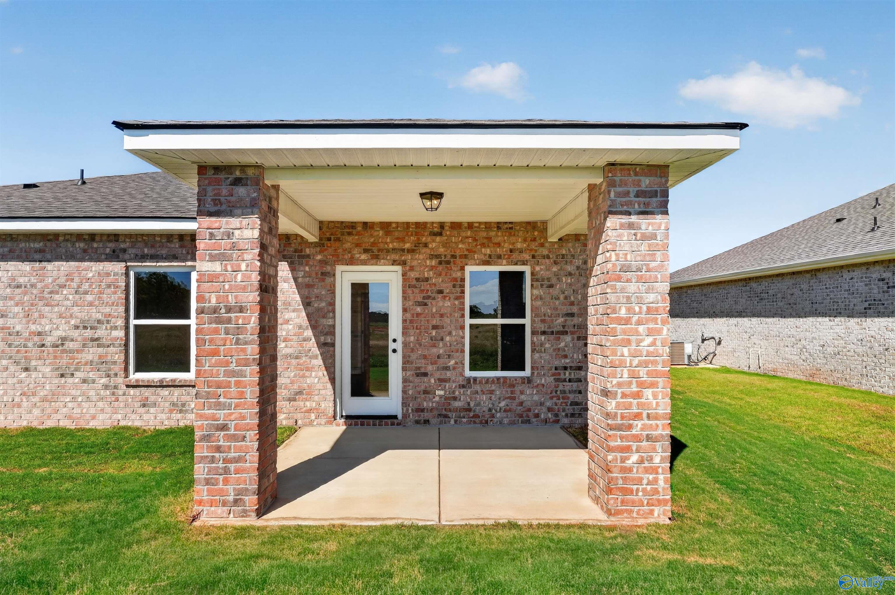 Covered brick patio with glass back door at Davidson Homes The Butler plan in Clearview, Hazel Green, Alabama
