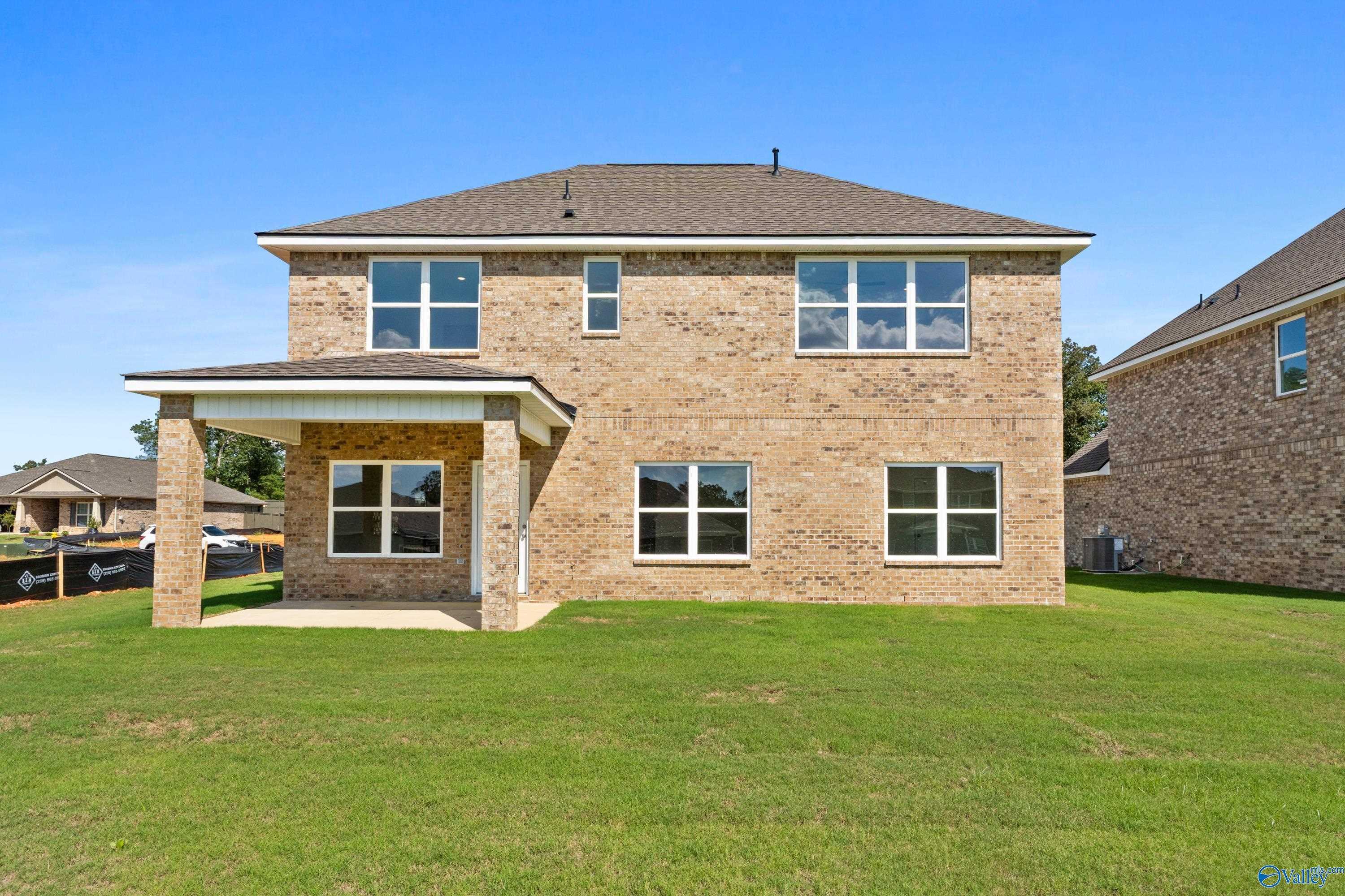 Two-story brick home with covered back patio, large windows, and green lawn in Creek Grove, New Market, Alabama - Davidson Homes The Shelby A