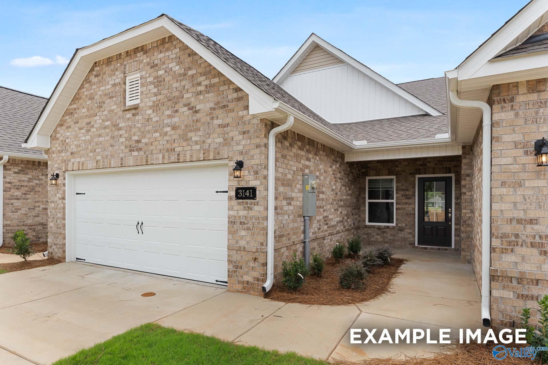 Modern brick single-story 3-bedroom home with 2-car garage and landscaped front yard in The Retreat at Hollon Meadow, Decatur, Alabama