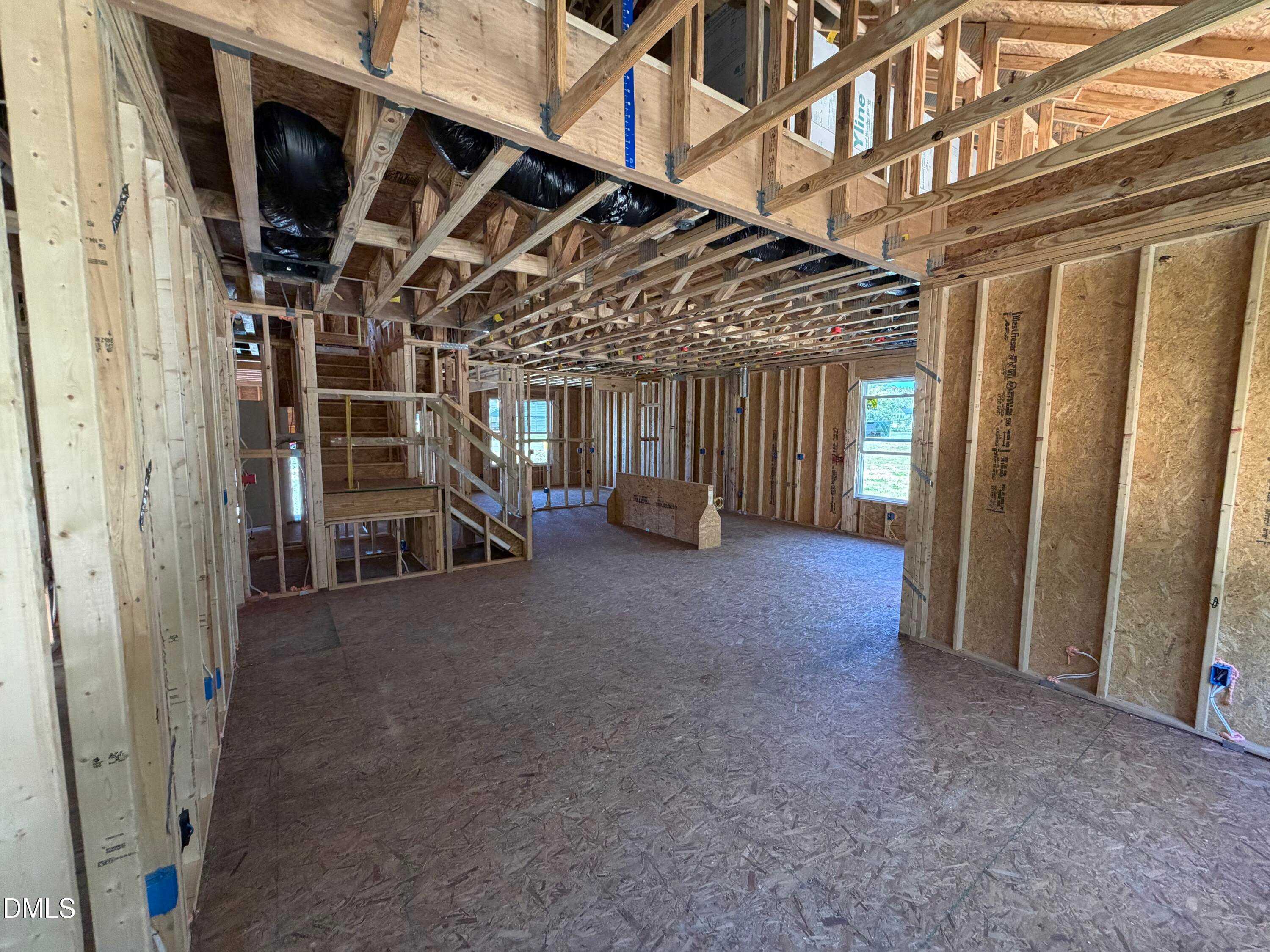Exposed wooden framing with open two-story layout, staircase, and ductwork in Davidson Homes The Ash B, Lillington, NC