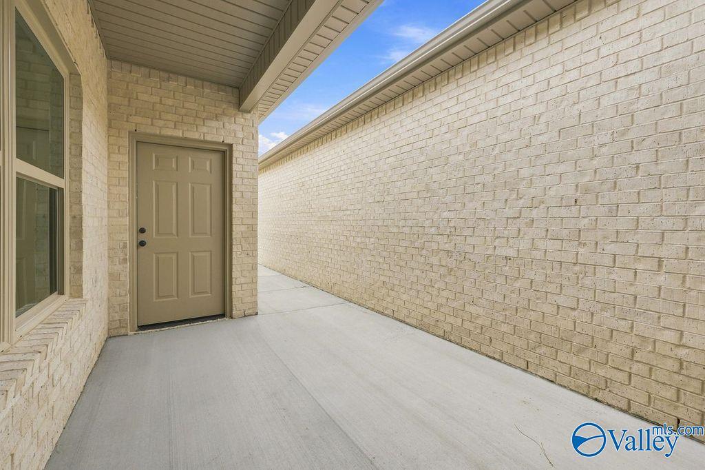 Covered side patio with brick exterior at The Camilla C floor plan in The Retreat at Cain Park, Hartselle, Alabama.