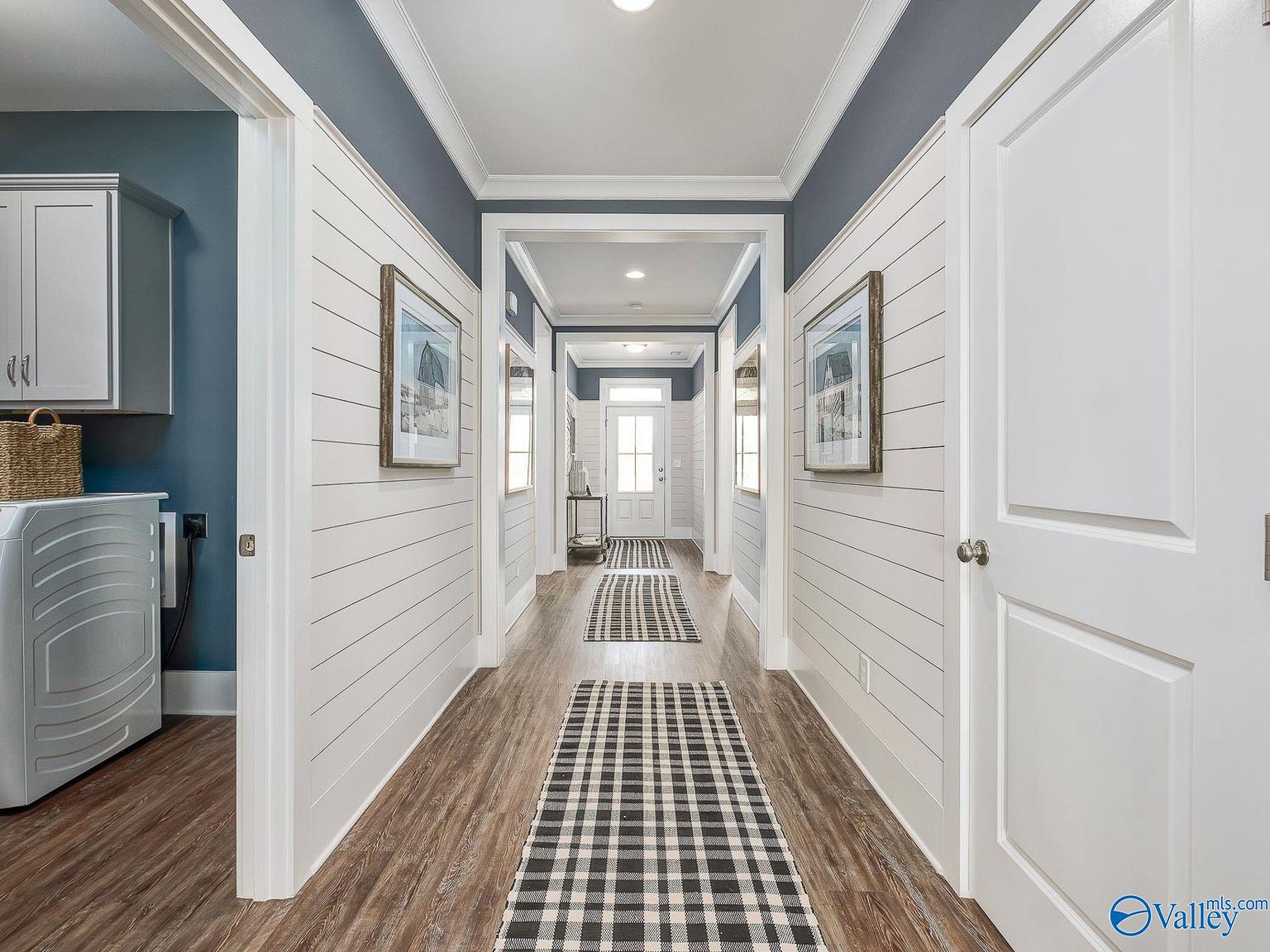 Elegant shiplap hallway with checkered runner rug and laundry nook in Davidson Homes The Everett, Toney, Alabama