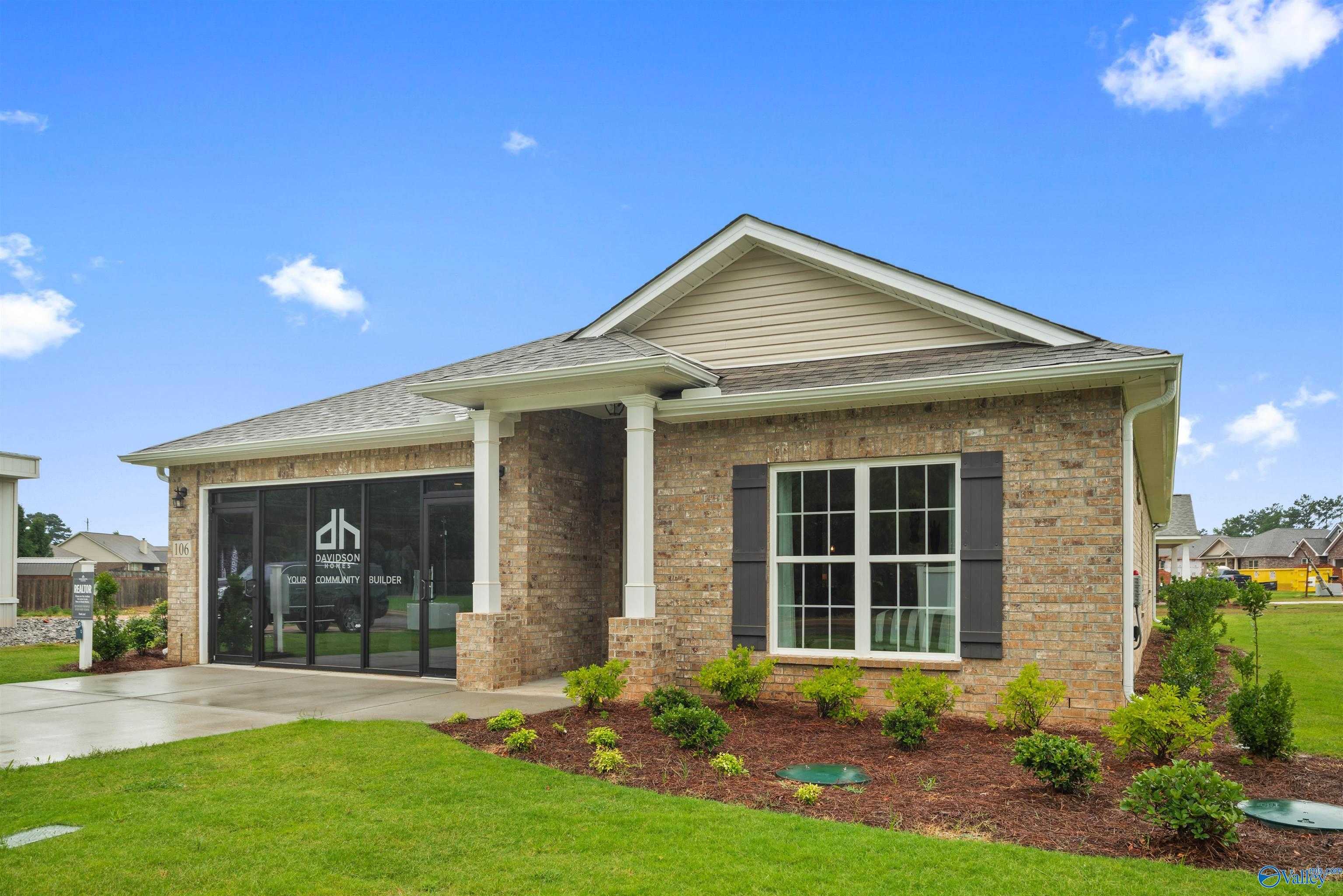 Single-story 4-bedroom Davidson Homes The Daphne brick exterior with 2-car garage and front porch in Durham Farms, Harvest, Alabama