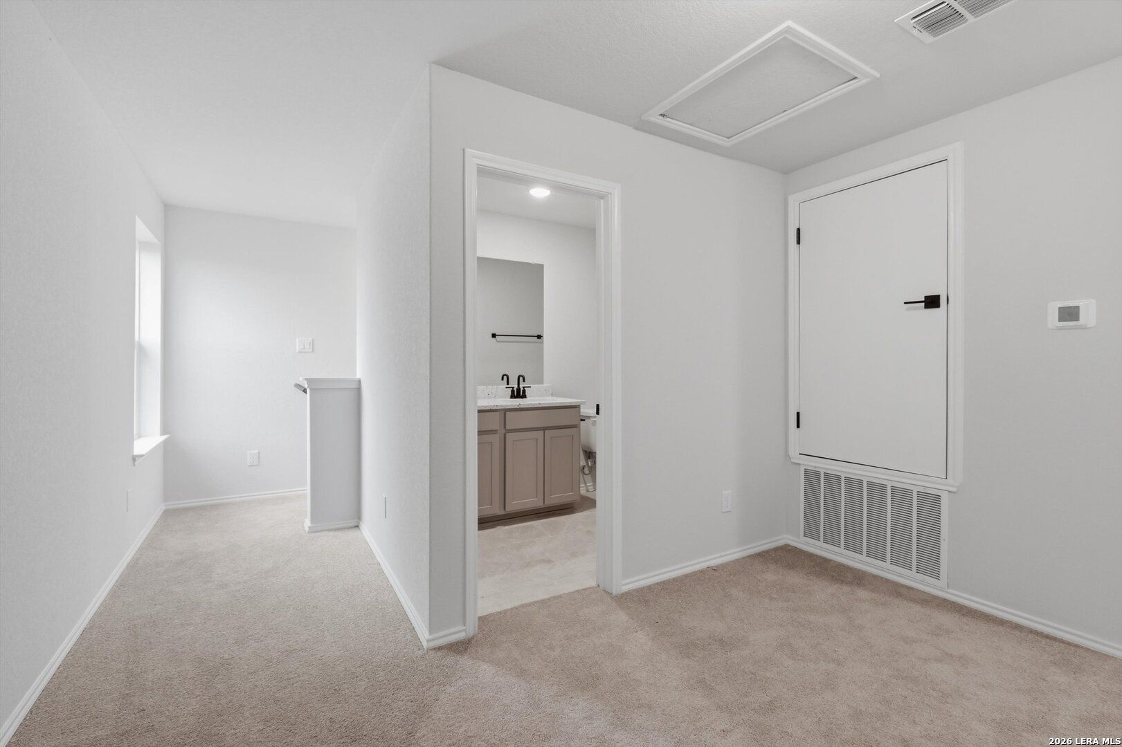 Spacious carpeted upstairs bedroom with en-suite bathroom, double vanity, and walk-in closet in Davidson Homes The Blanco C, San Antonio