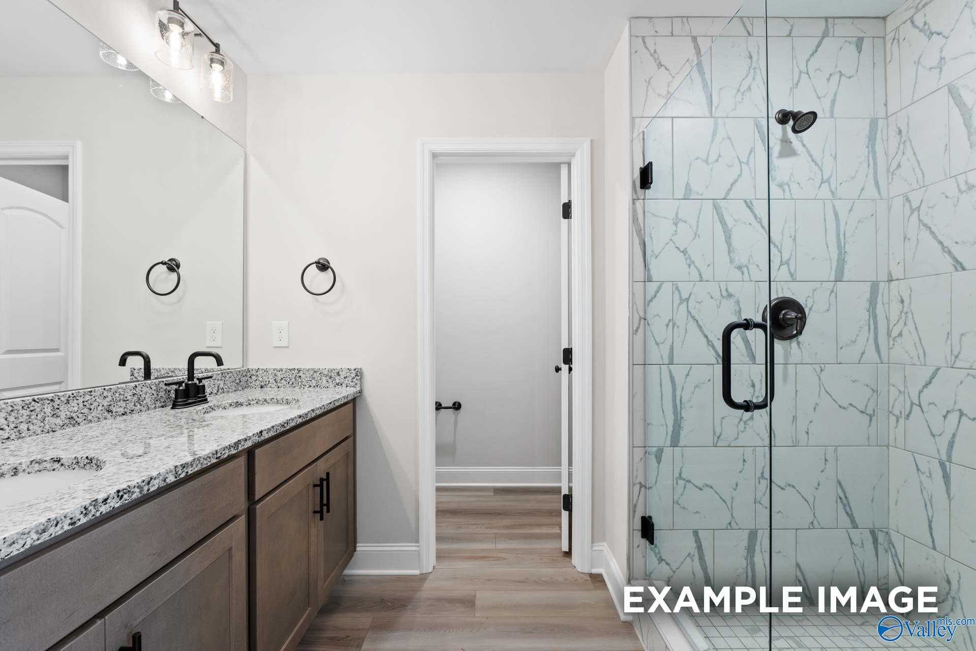 Modern master bathroom featuring double quartz vanity, frameless glass shower, subway tile in Davidson Homes The Camden D, Huntsville AL
