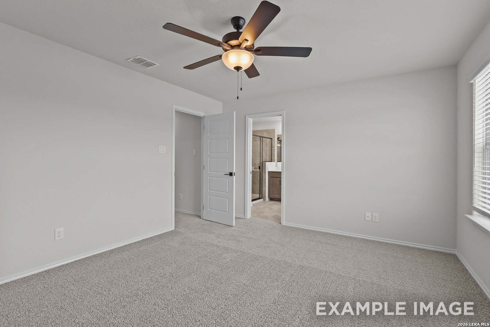 Spacious bedroom with ceiling fan and en-suite bathroom in The Florence D floor plan at Cedar Heights, San Antonio, Texas.