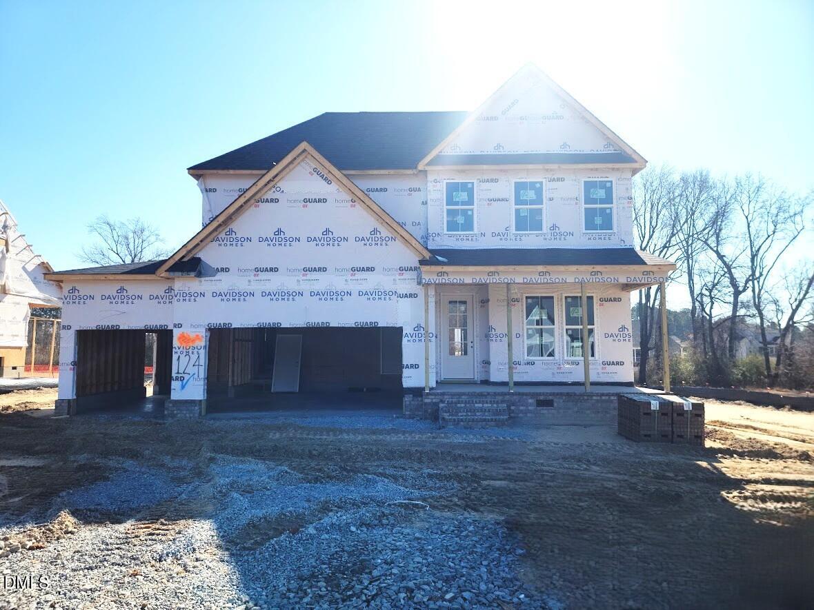 Two-story Ashport G home under construction with 3-car garage and front porch in Tobacco Road, Angier, North Carolina