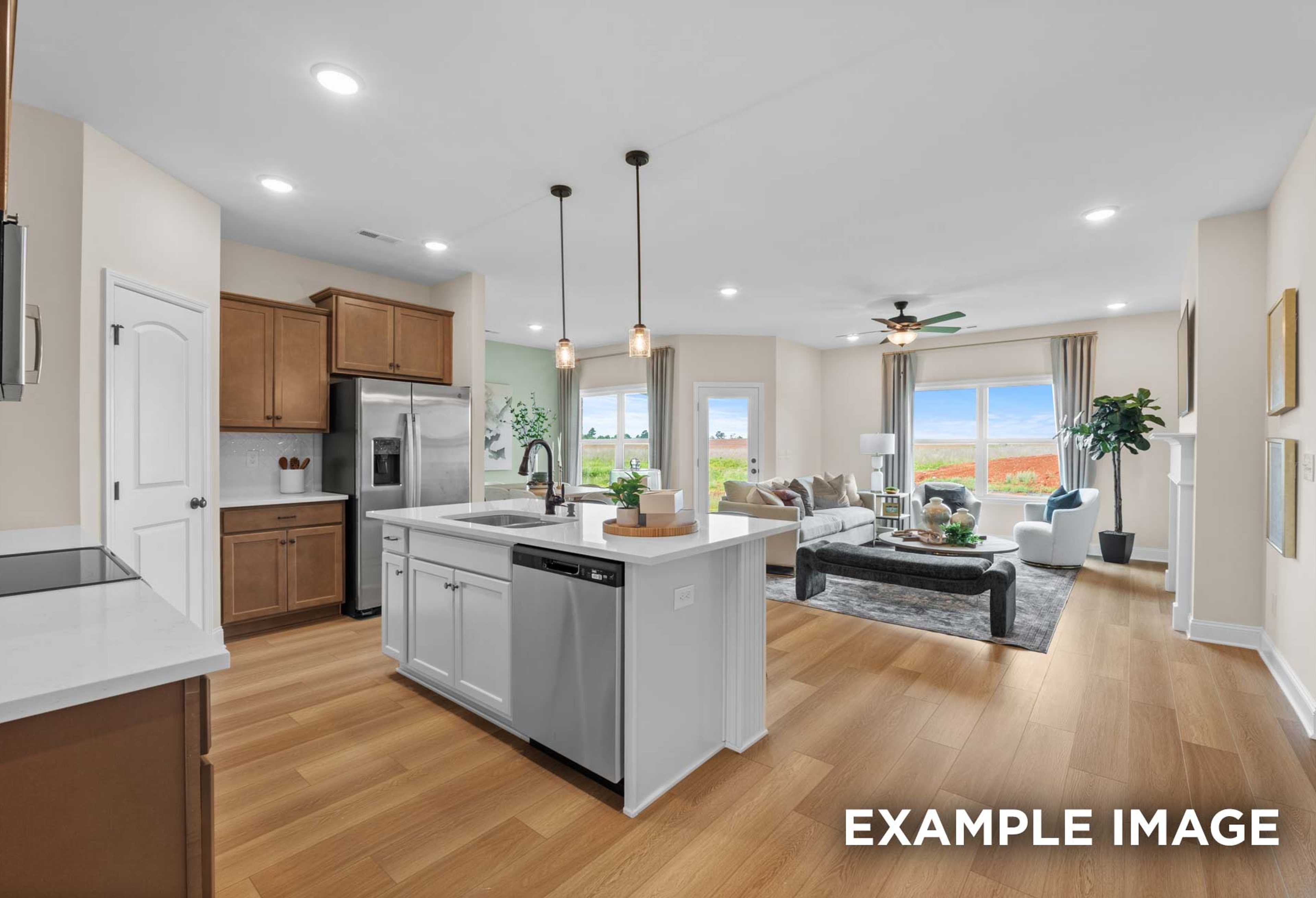 Spacious open-concept kitchen and living area in The Laurel M with white shaker cabinets, large island, stainless appliances, and large windows