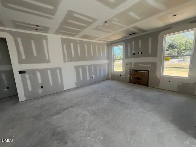 Unfinished great room with fireplace and large windows under construction in Davidson Homes The Ash C, Lillington, North Carolina