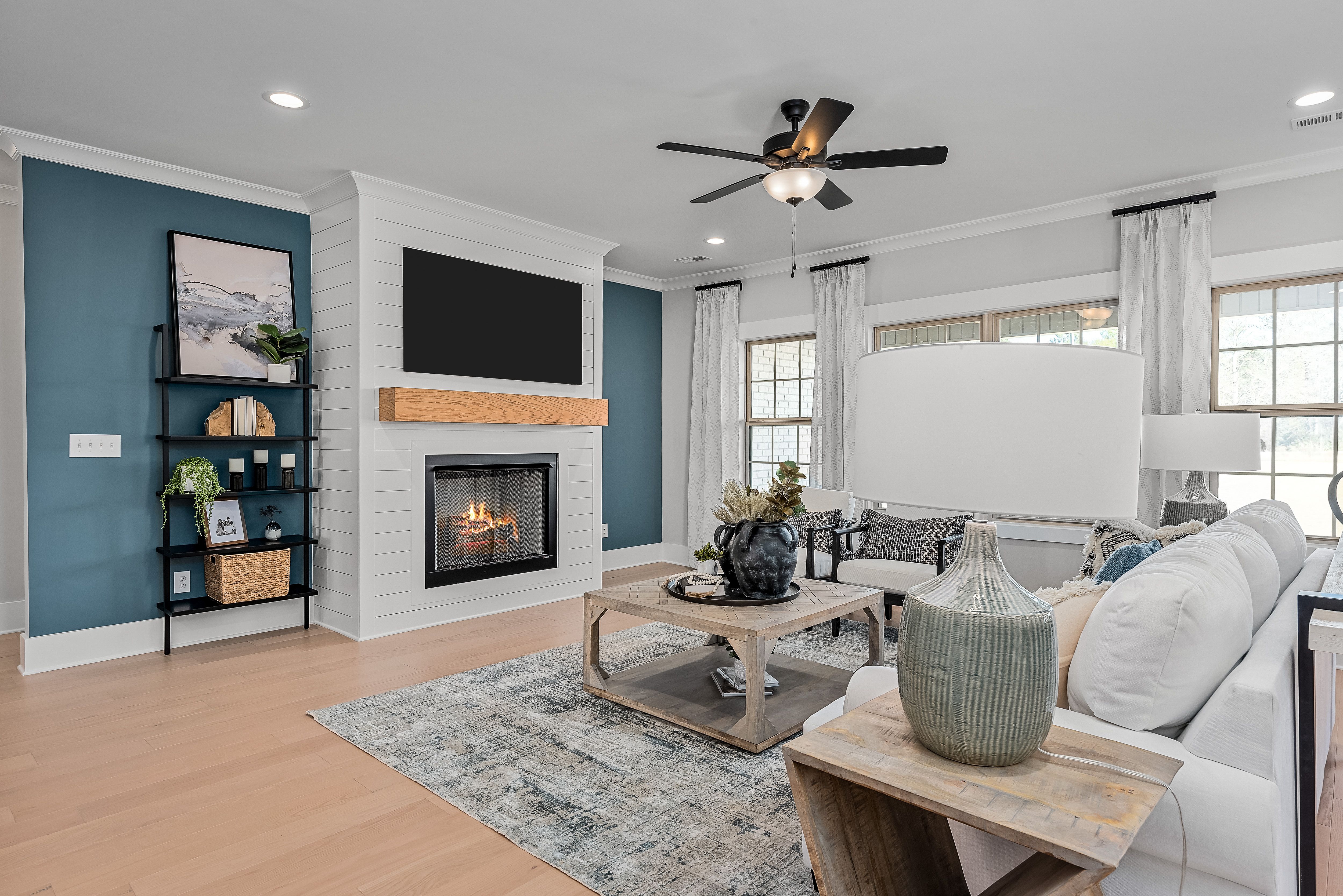Cozy living room at Cain Park in Hartselle Alabama with shiplap fireplace, white sectional sofa, hardwood floors, and teal accent wall