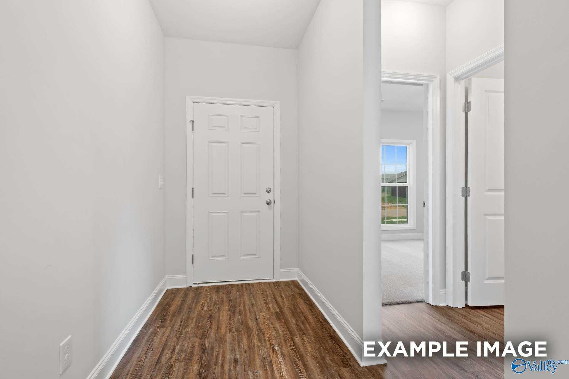 Bright hallway with hardwood floors, white doors, and natural light in The Asheville C 3-bedroom home, Meridianville, Alabama
