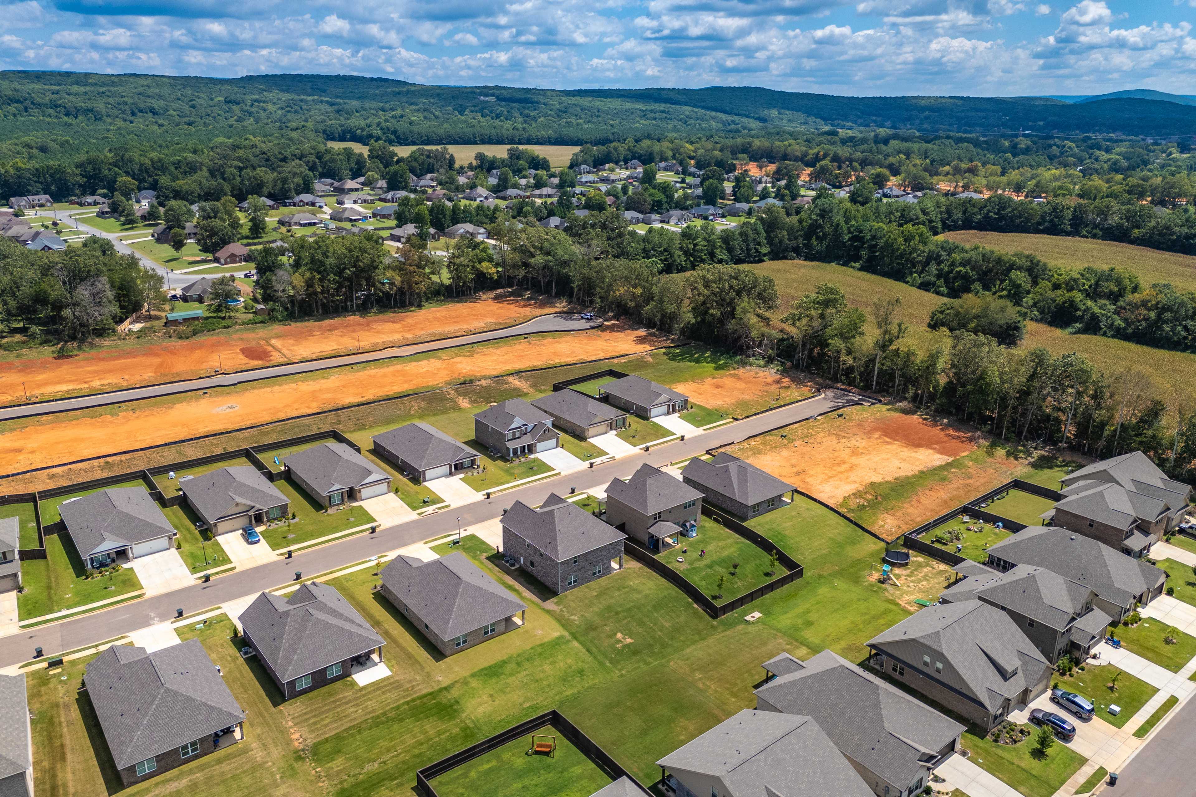 Aerial view of Creek Grove neighborhood in New Market Alabama with new Davidson Homes, construction sites, and surrounding woods