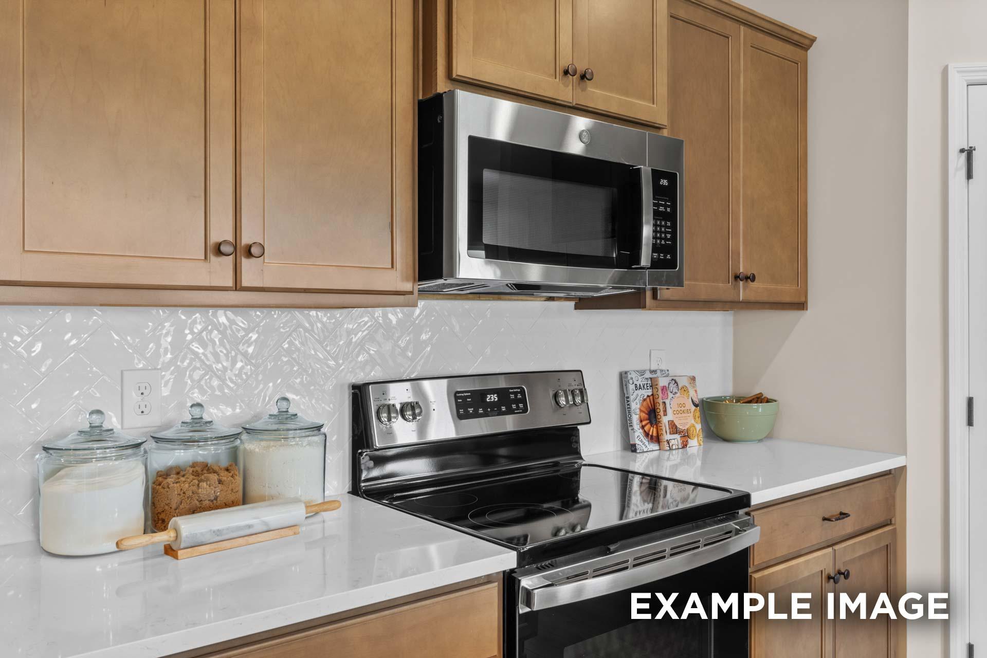 Modern Laurel M kitchen with shaker cabinets, stainless steel appliances, subway tile backsplash, and quartz counters